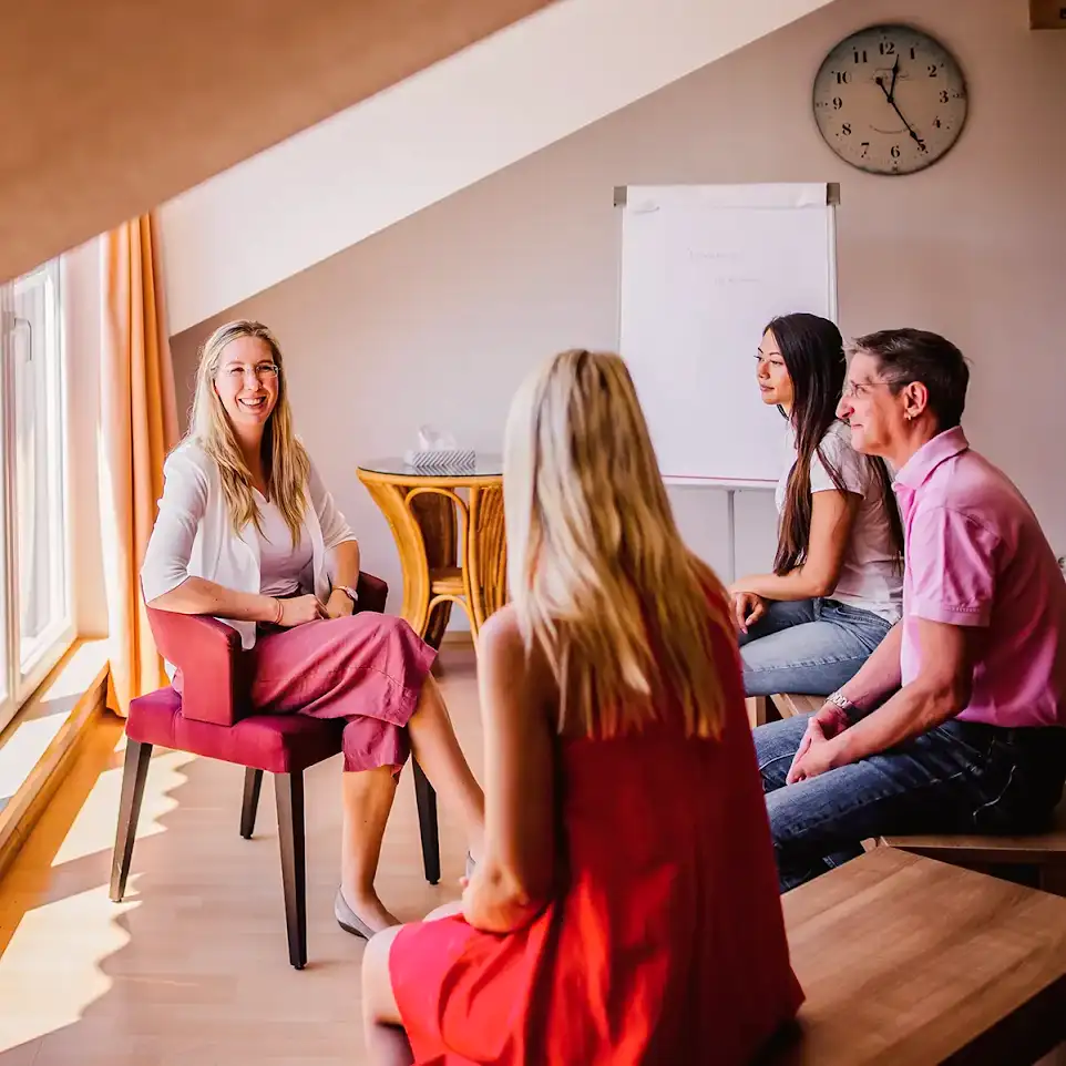Eine Gruppentherapie mit mehreren Patienten die beisammen sitzen findet statt.