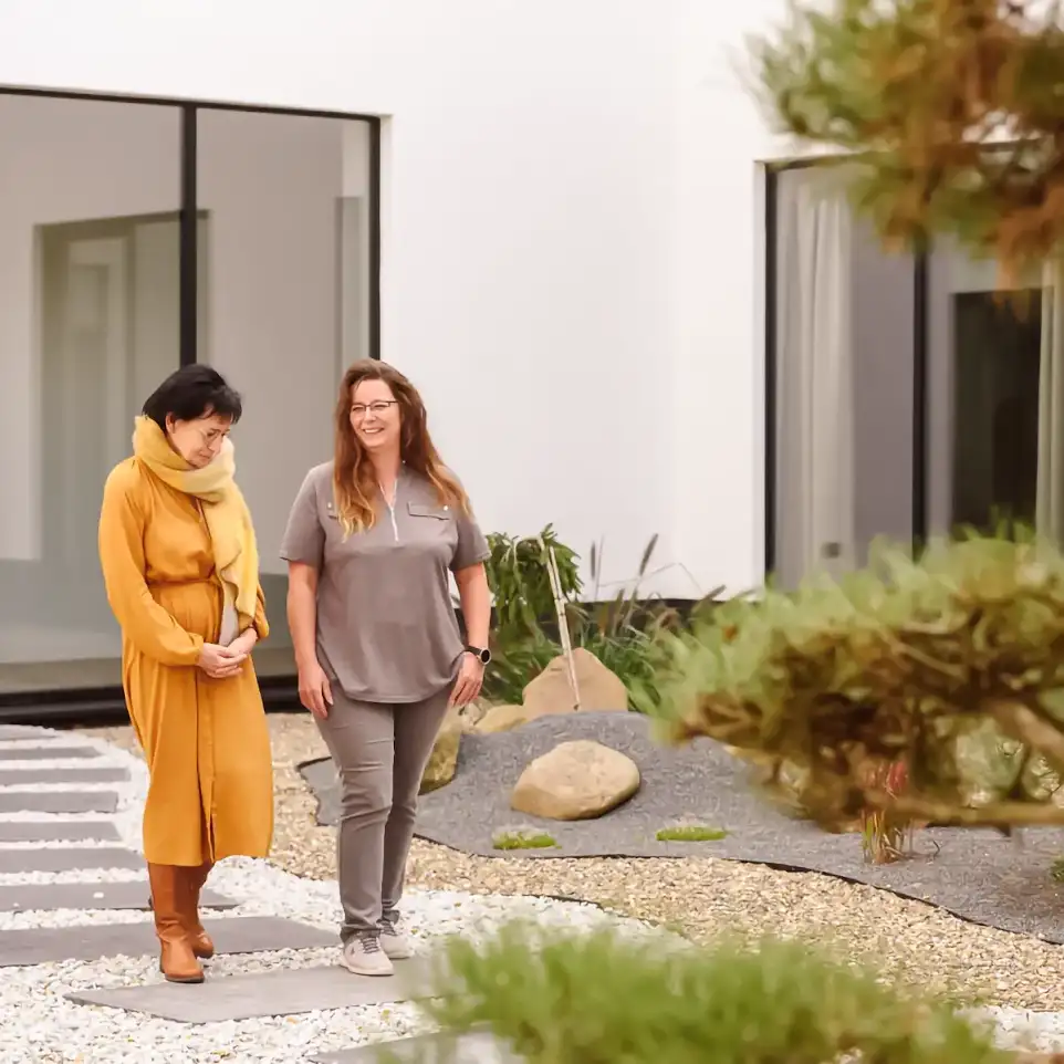 Zwei Mitarbeiterinnen der Vincera Kliniken gehen durch den Innenhof und unterhalten sich.