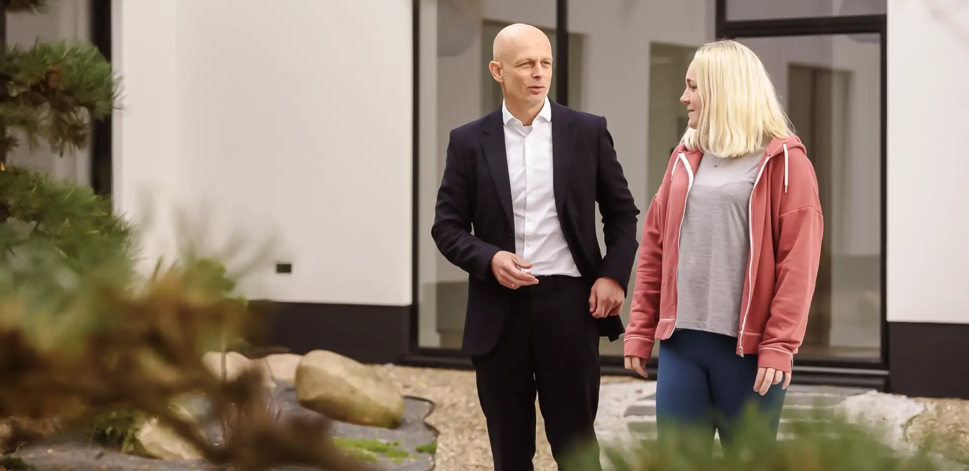 Ein Psychotherapeut und eine Patientin gehen nebeneinander her und unterhalten sich.