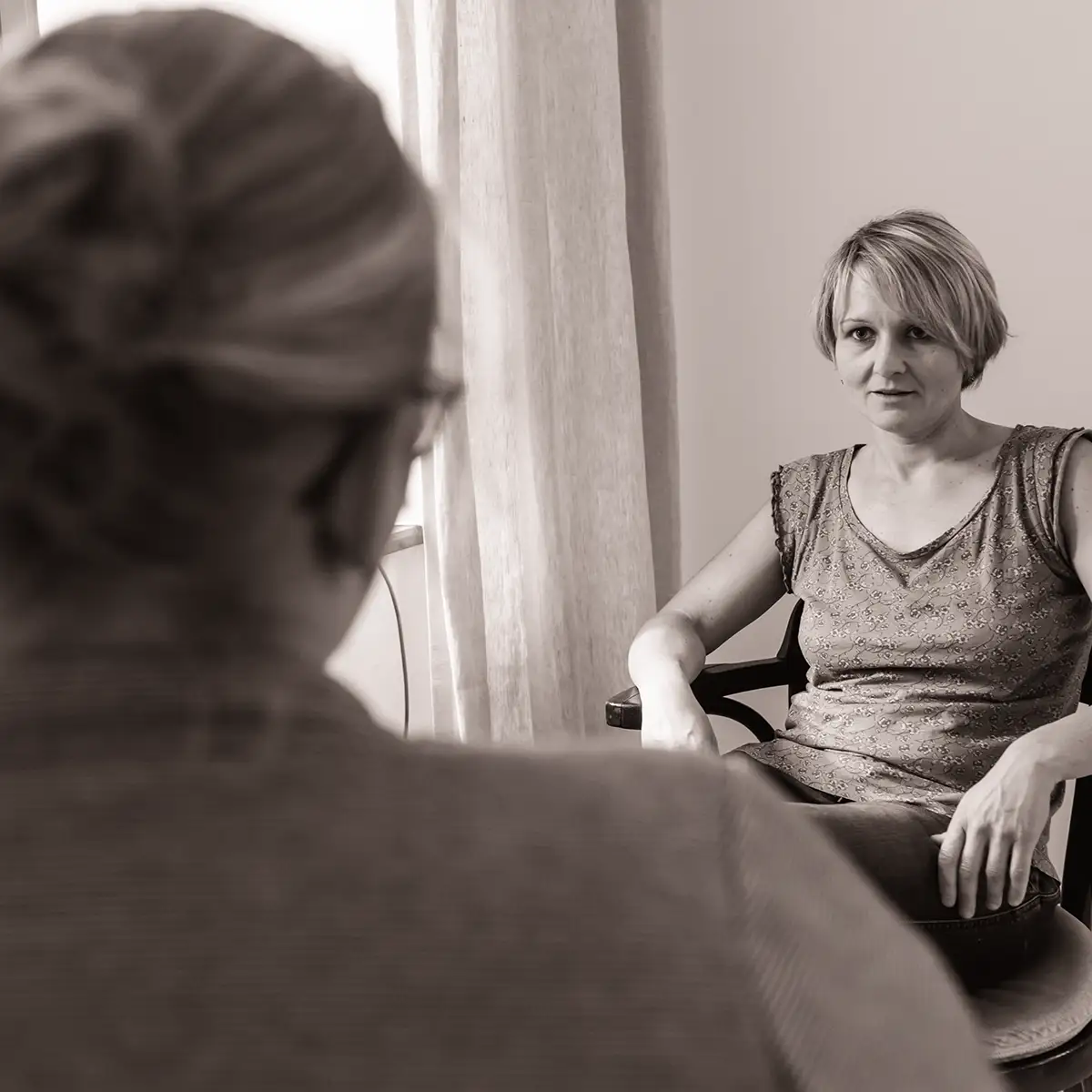Schwarz-weiß-Bild eines Einzelgesprächs zwischen Therapeutin und Patientin