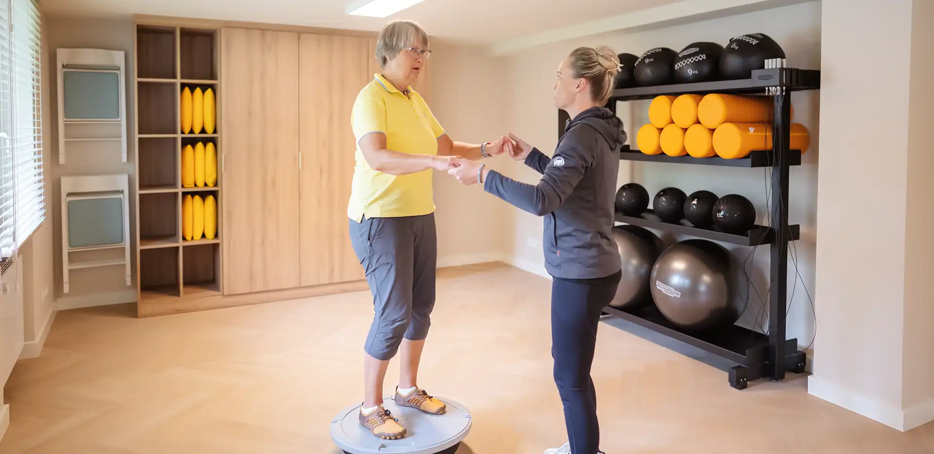 Eine Therapeutin macht mit einer Patientin Stabilisationstraining.