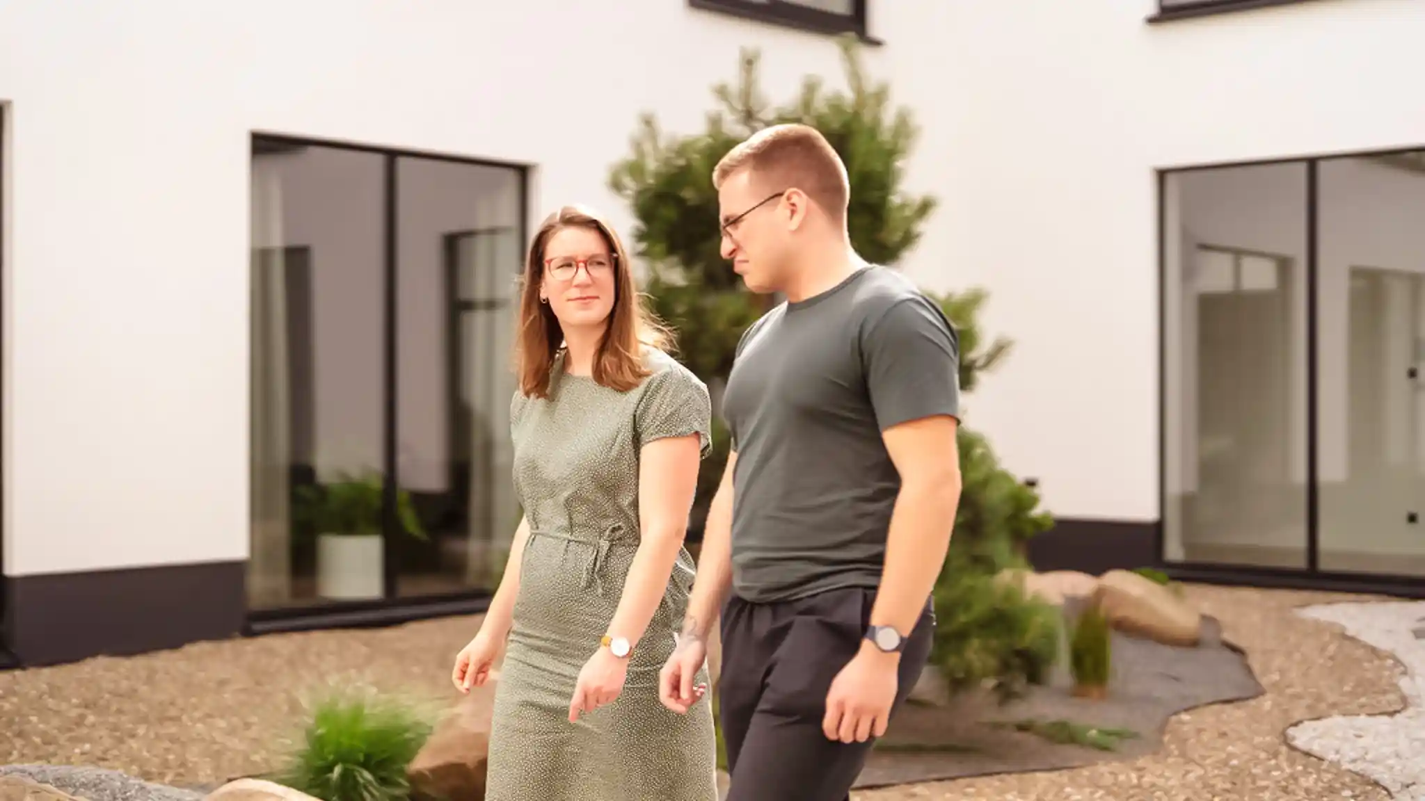 Ein Patient spaziert neben seiner Ärztin durch den Innenhof einer Vincera Privatklinik