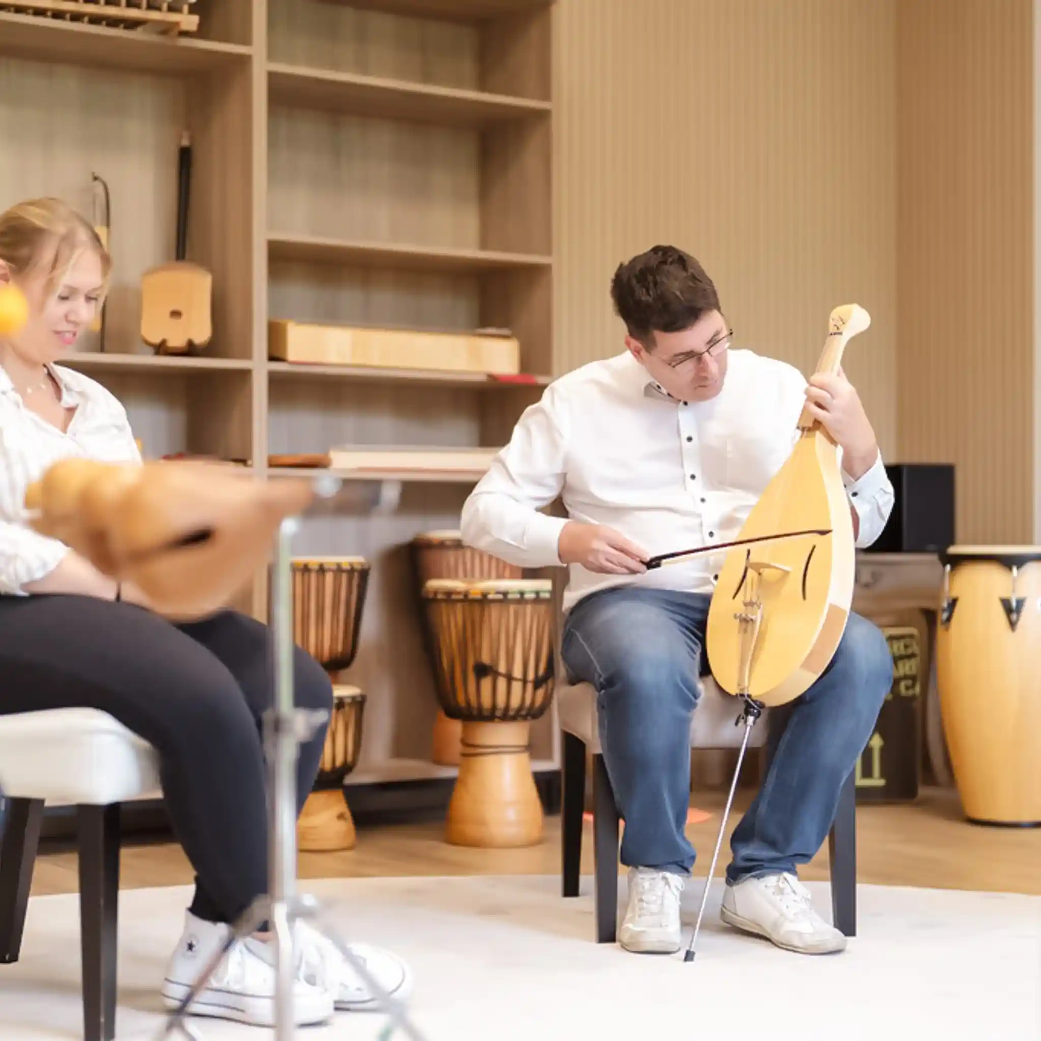 Ein Patient spielt im Rahmen der Musiktherapie auf einem Saiteninstrument.