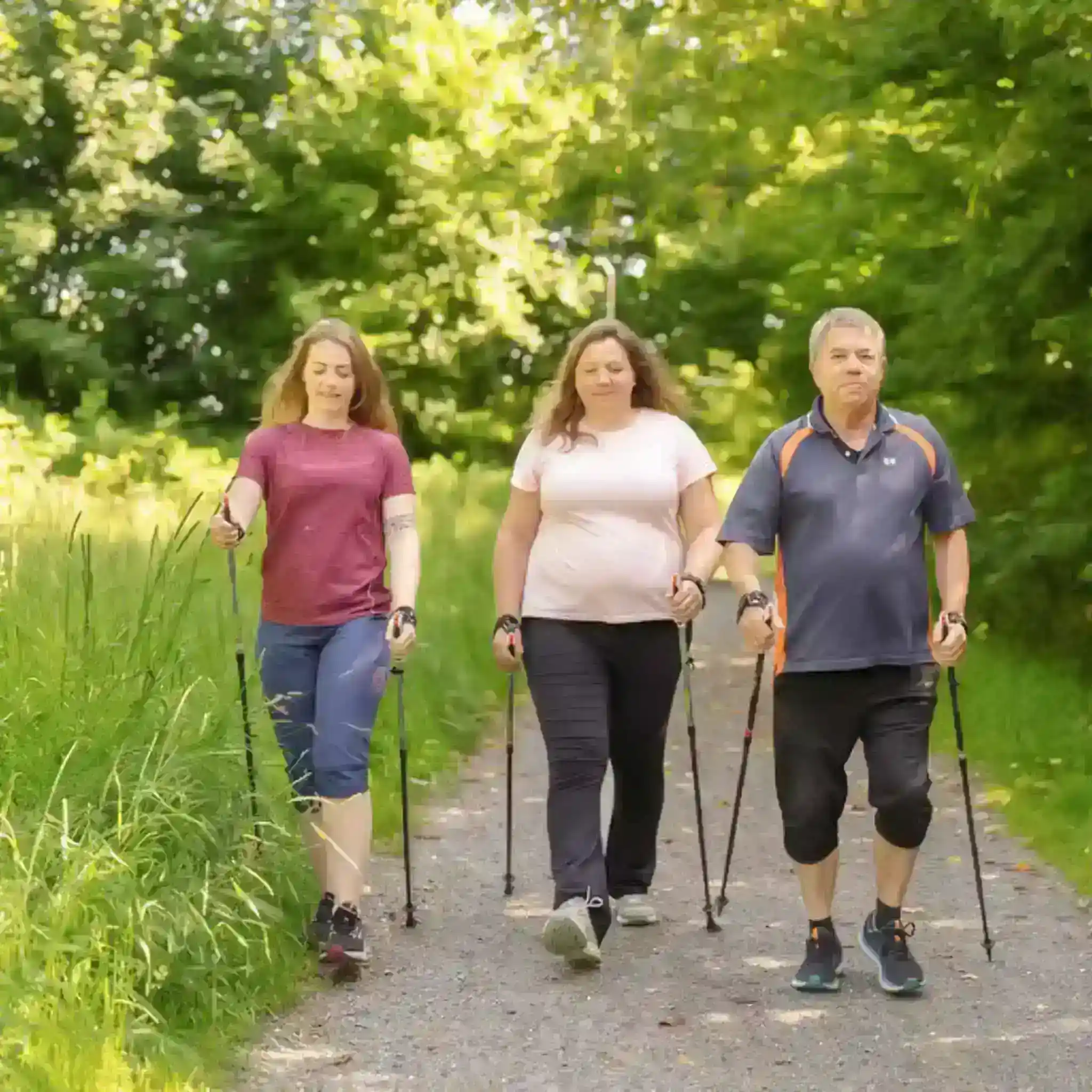 Vier Patientinnen gehen mit Wanderstöcken nebeneinander her.