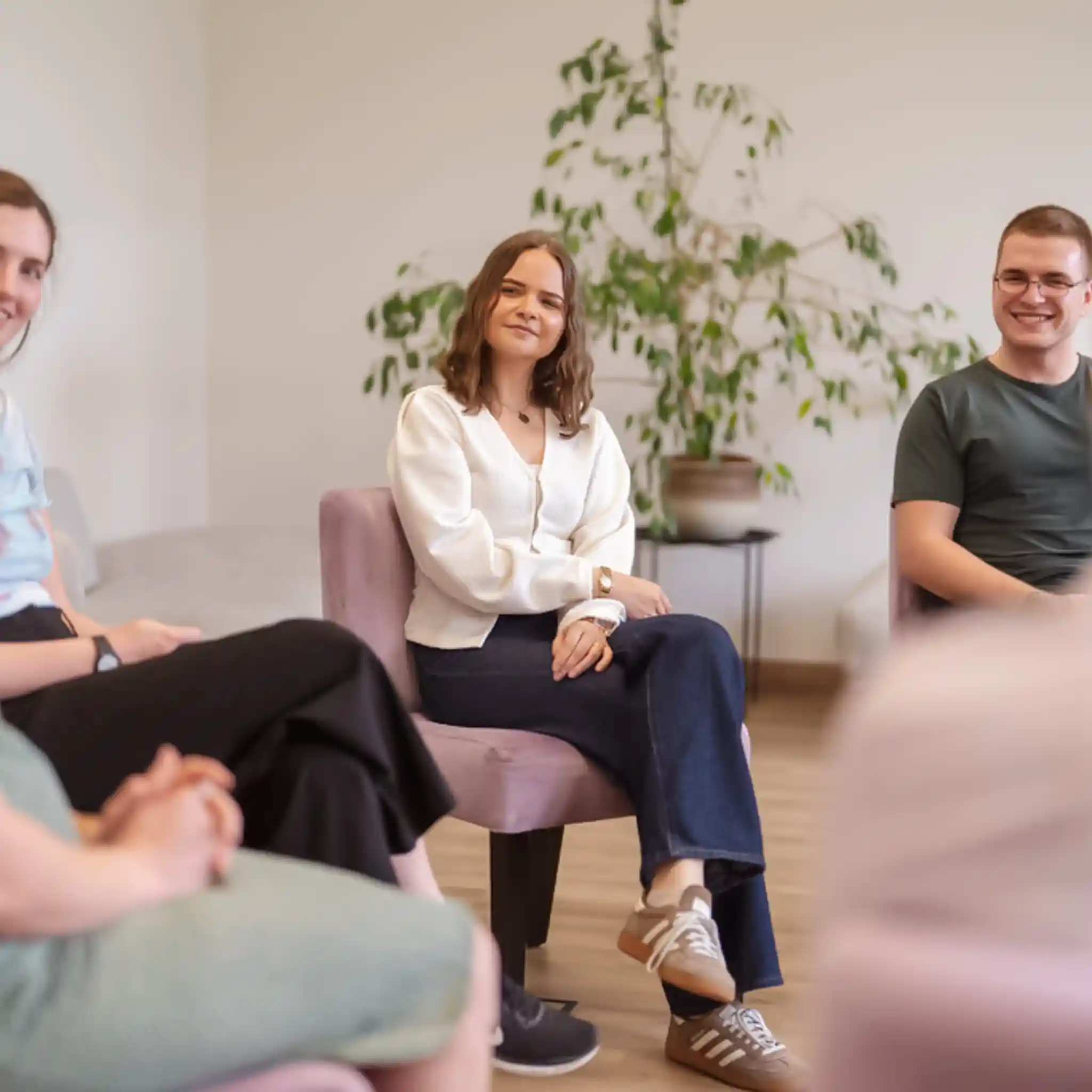 Patientin sitzt bei einer Gruppentherapie im Stuhlkreis.
