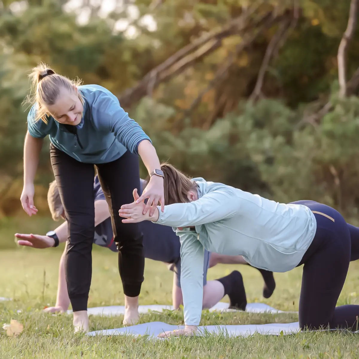 Eine Yogalehrerin hilft einer Patientin bei der Ausführung einer Yogaposition.