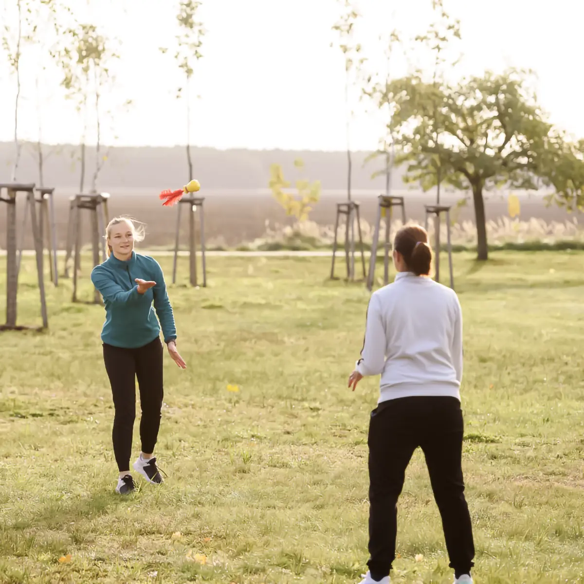 Zwei Patientinnen spielen im Garten gemeinsam ein Ballspiel.