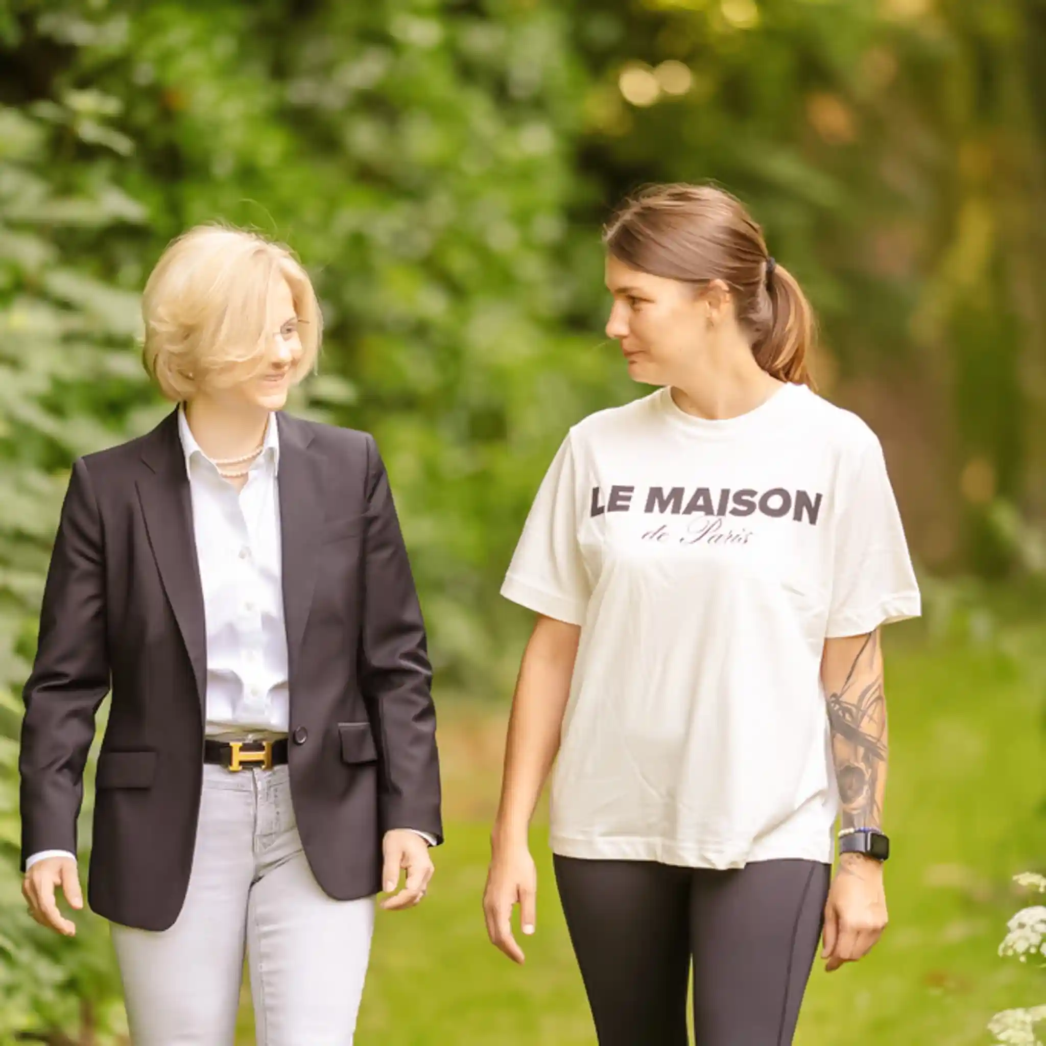 Eine Therapeutin läuft mit einer Patientin durch den Garten