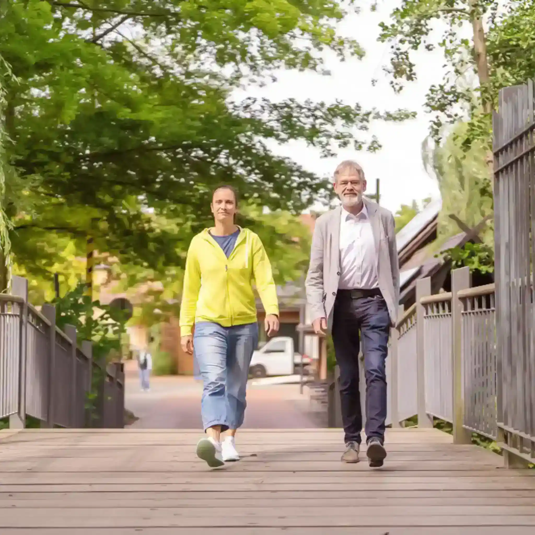 Ein Mann und eine Frau laufen über eine Holzbrücke