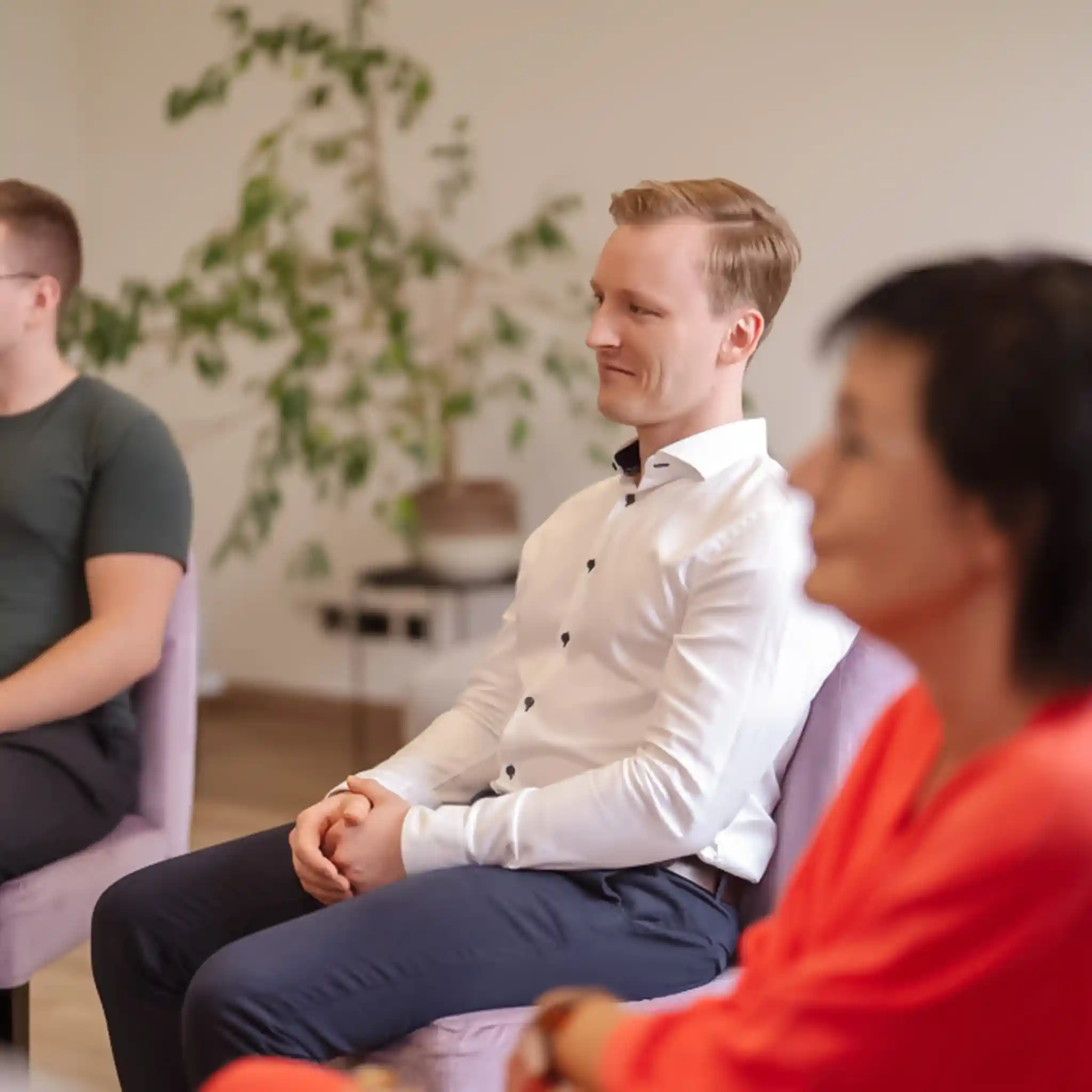Ein Mann sitzt im Stuhlkreis bei einer Gruppentherapie