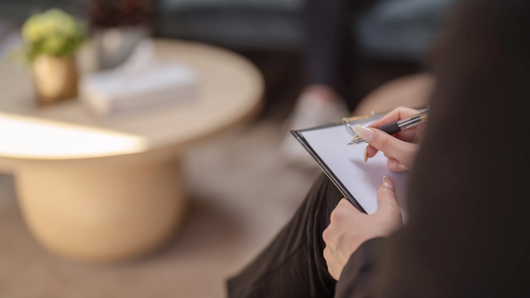 Eine Therapeutin mit einem Klemmbrett auf dem Schoß