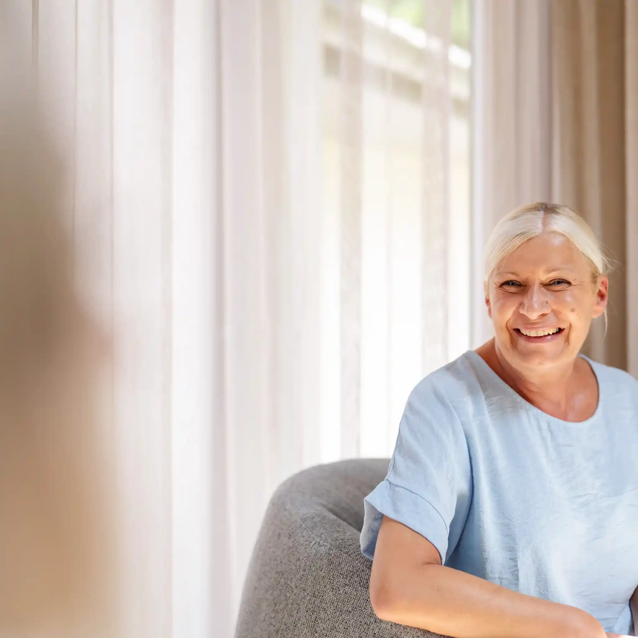 Eine Patientin lacht in die Kamera.