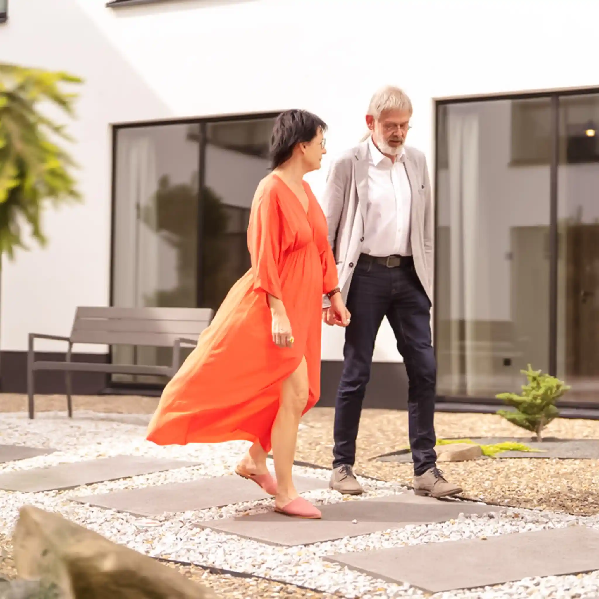 Eine Frau und ein Mann laufen nebeneinander vor einem Gebäude 