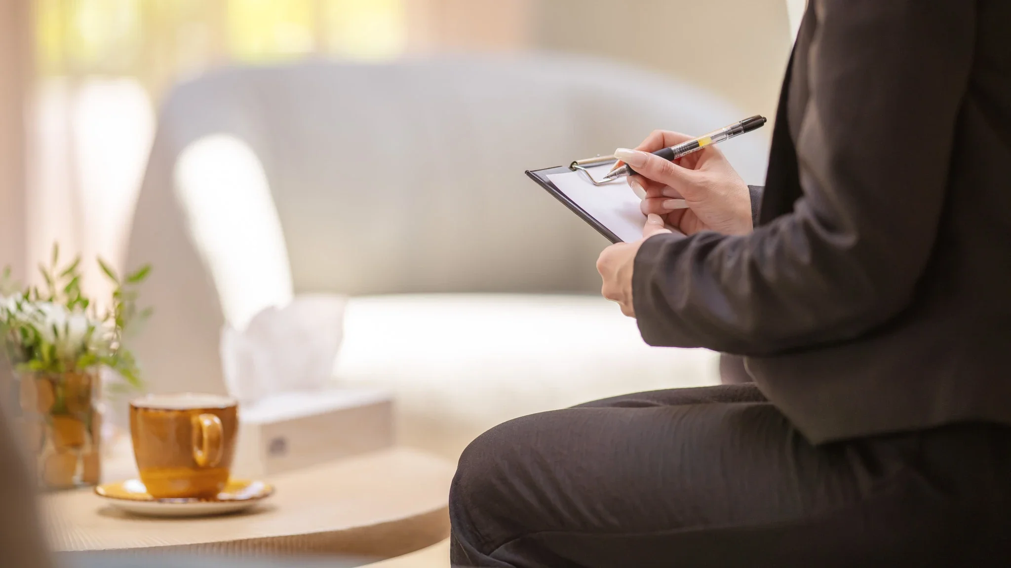 Eine Person beginnt etwas auf einem Klemmbrett zu notieren.