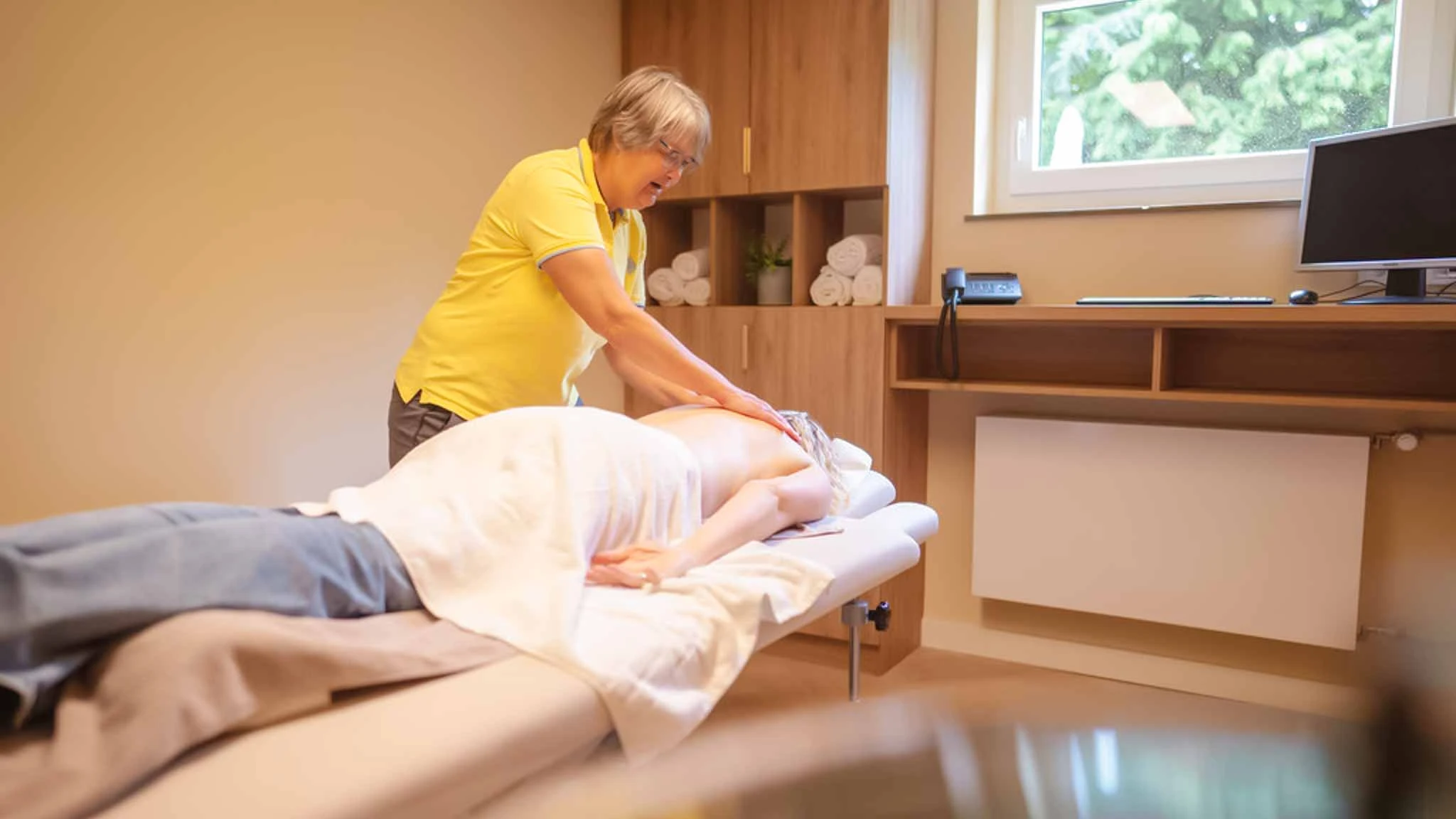 Physiotherapeutin führt eine Sportmassage durch
