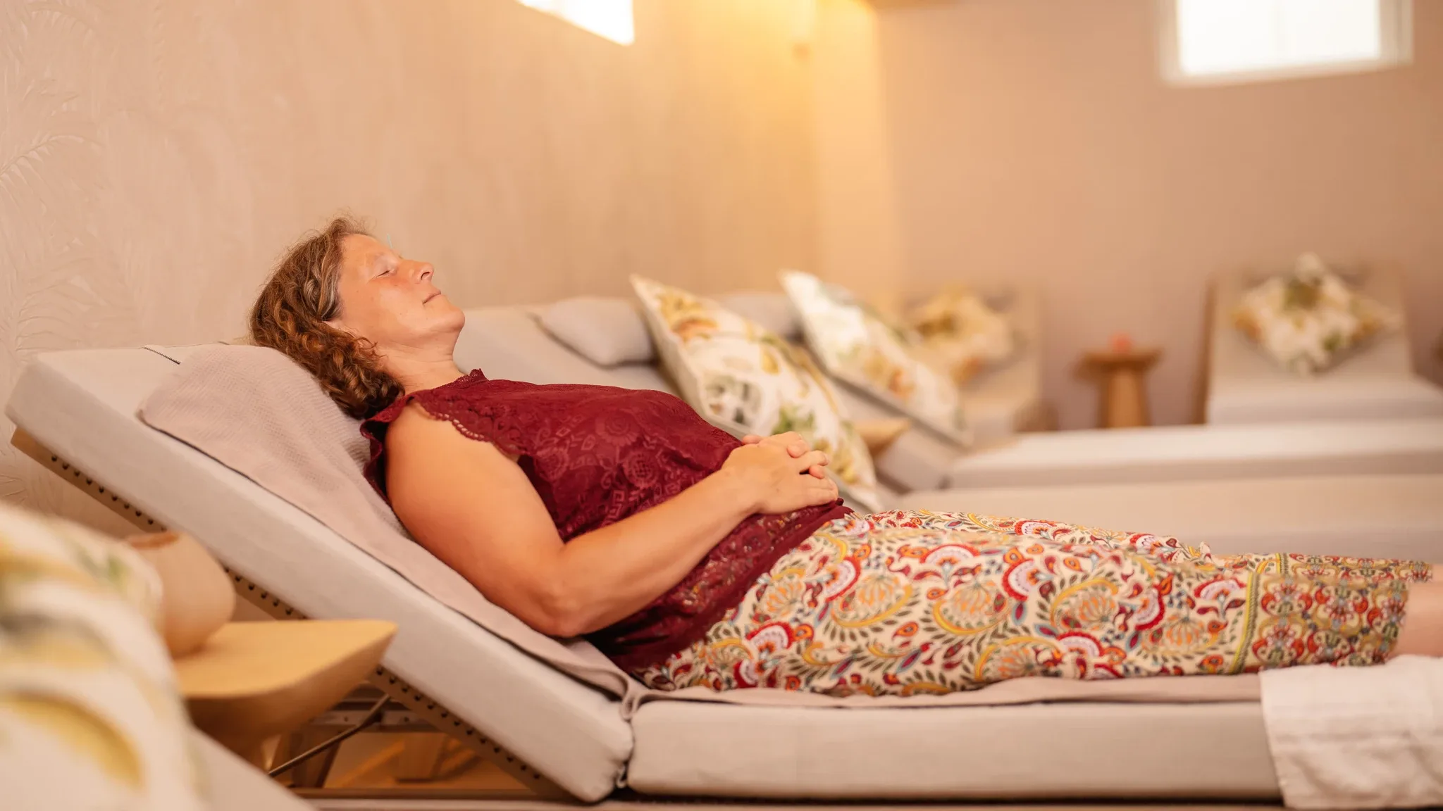 Eine Patientin liegt entspannt auf einer Liege in einem Raum