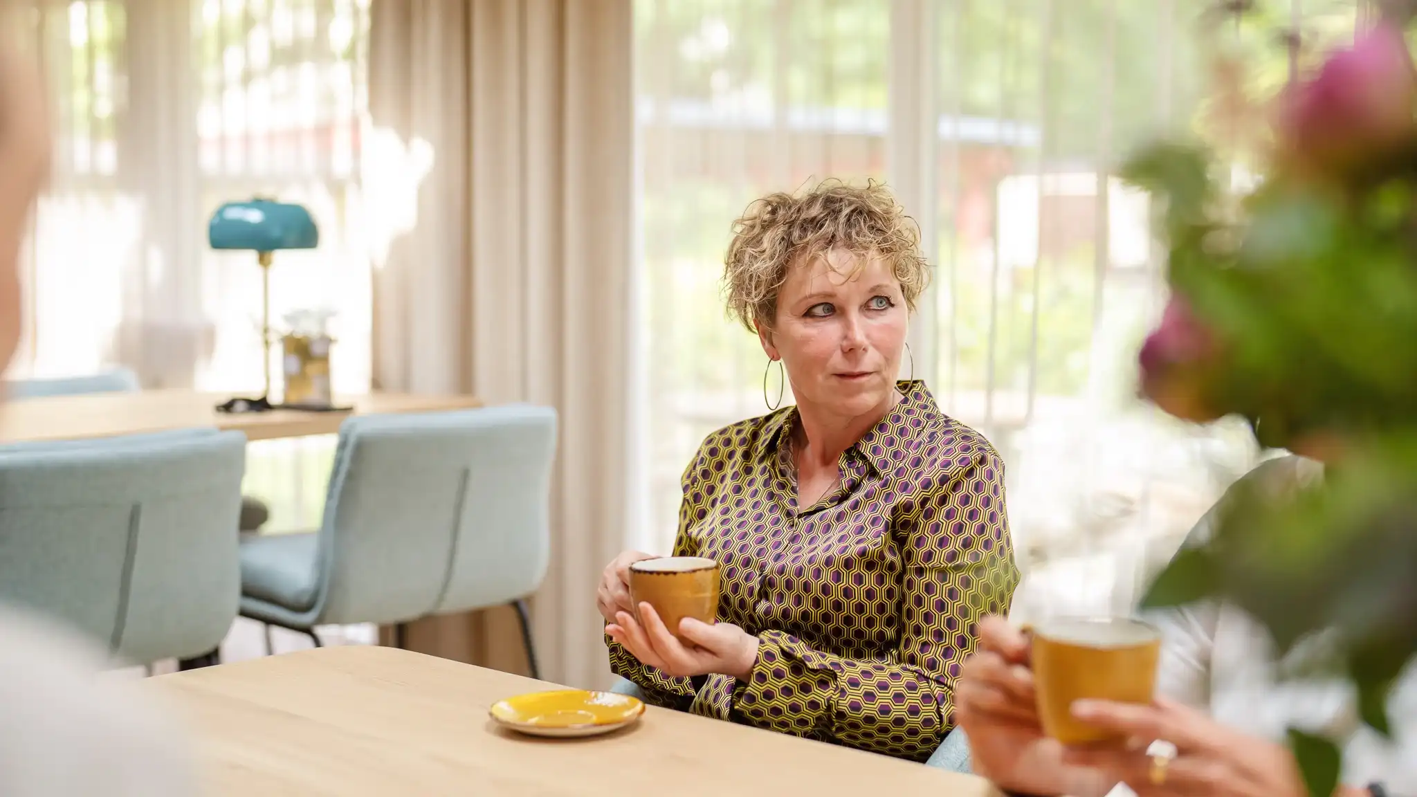 Eine Ärztin beim Kaffeetrinken mit Kollegen.