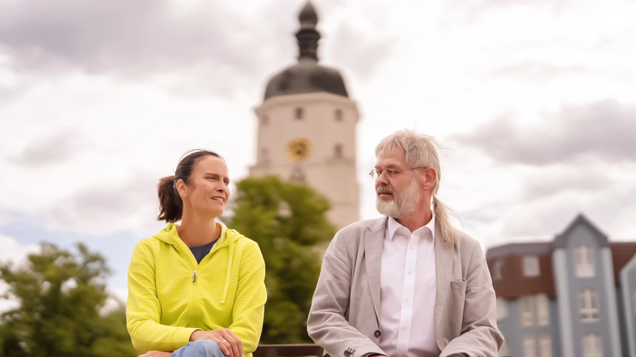 Eine Patientin mit Sommerdepression sitzt neben ihrem Psychiater auf einer Parkbank.