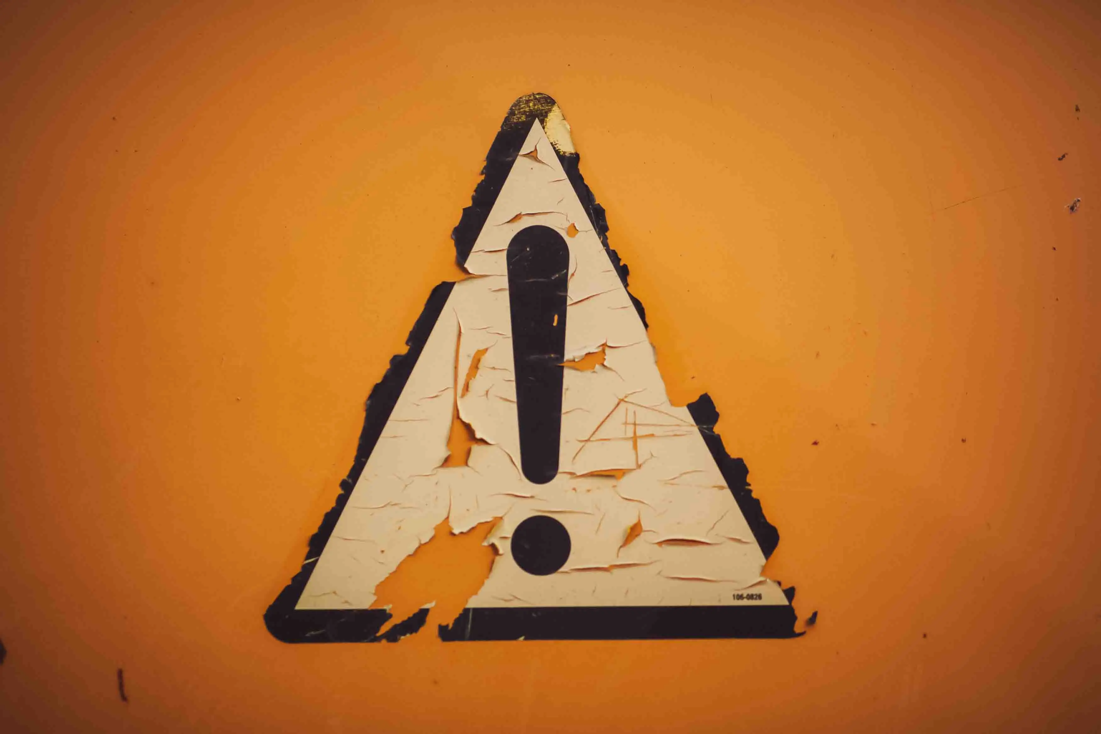 Ein Ausrufezeichen Warnschild auf orangenem Hintergrund.