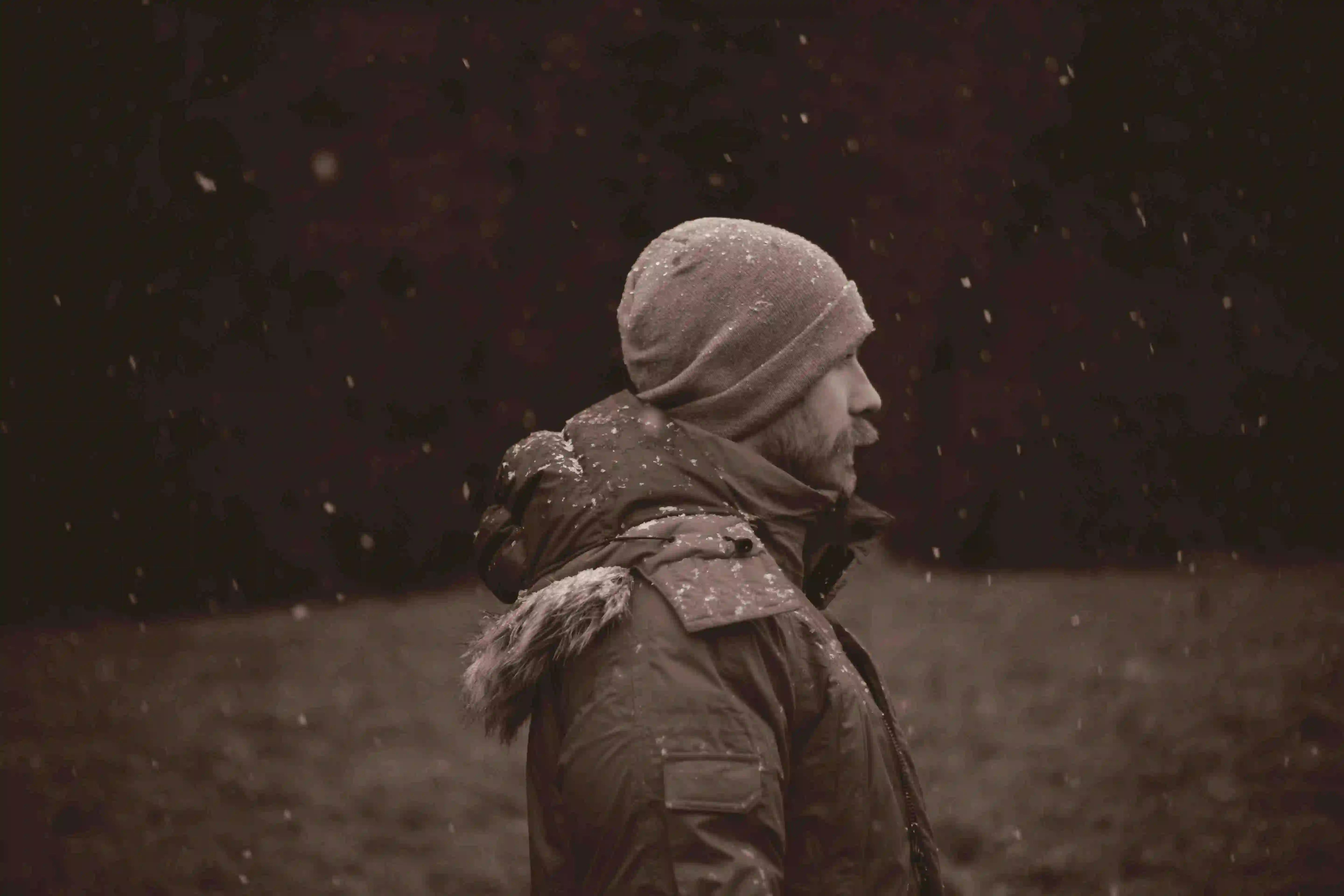 Ein Mann mit Winterdepression steht im Schnee.