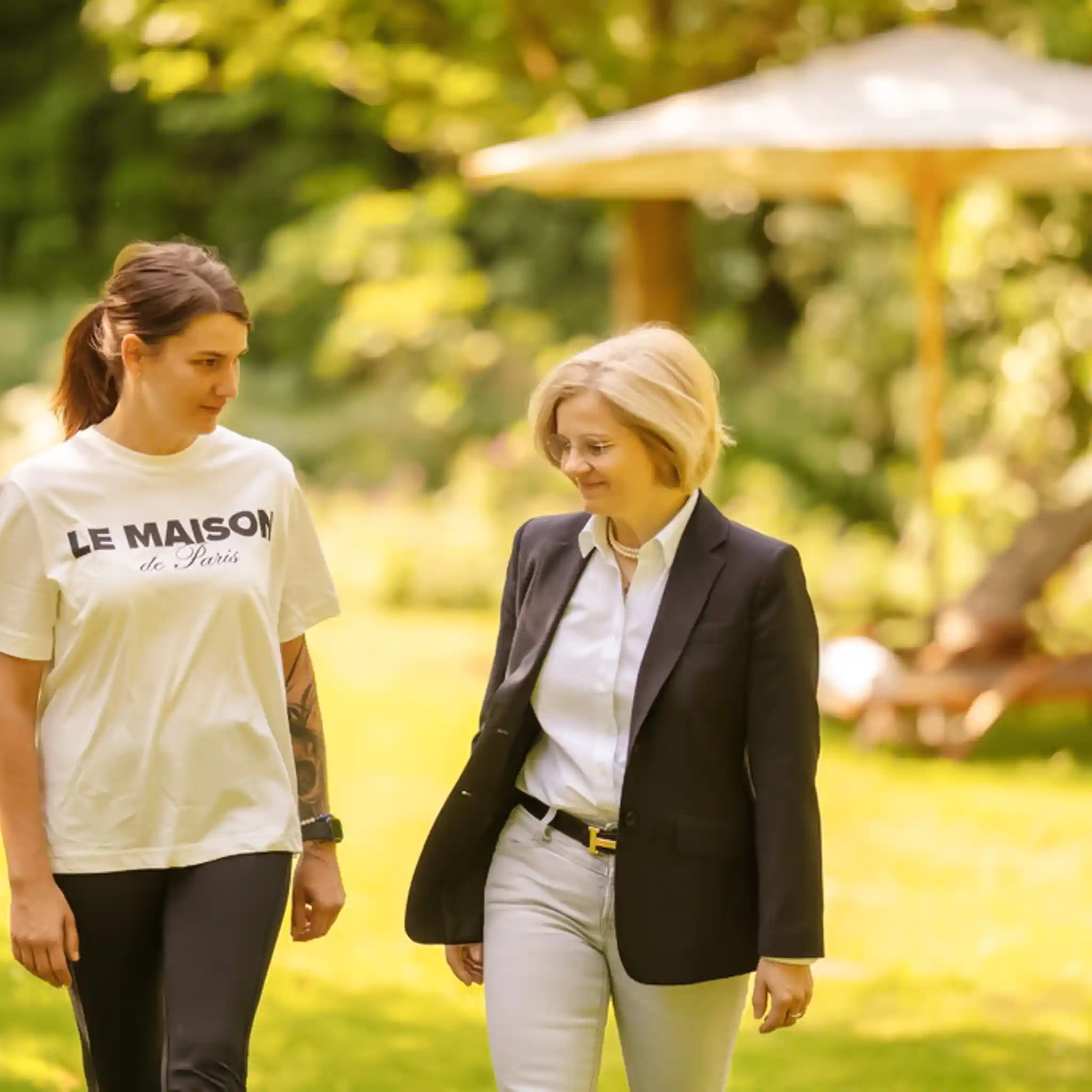 Zwei Frauen laufen durch den Garten und unterhalten sich