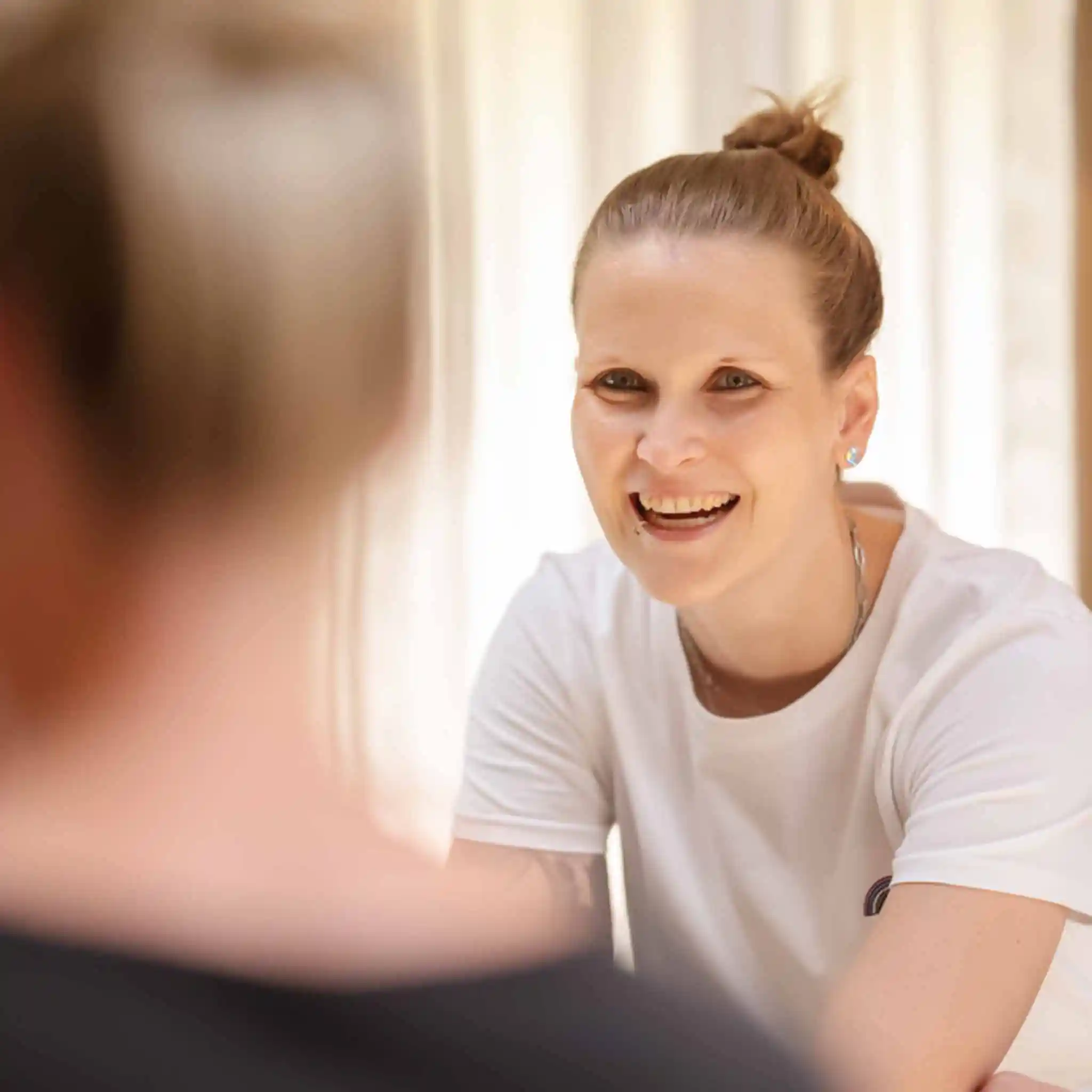 Eine lachende Frau in weißem T-shirt