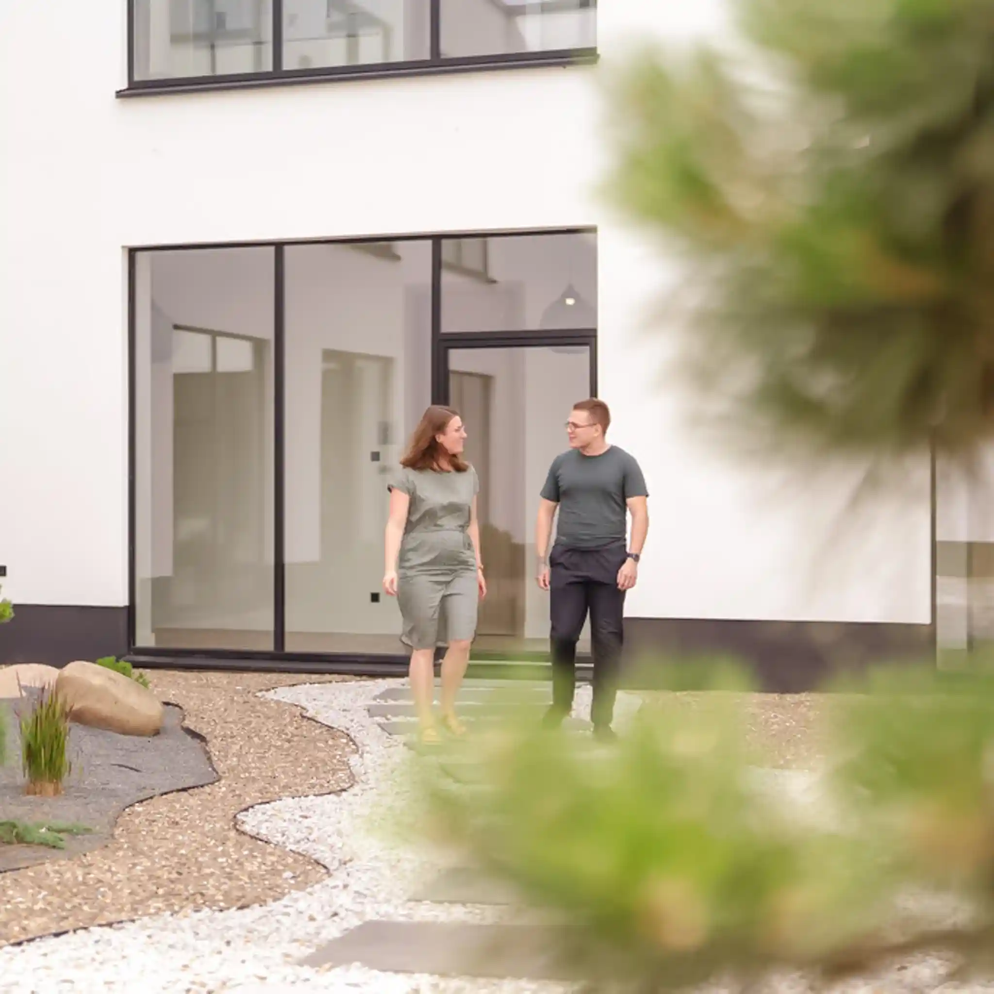 Ein Mann und eine Frau laufen draußen vor einem Gebäude und unterhalten sich