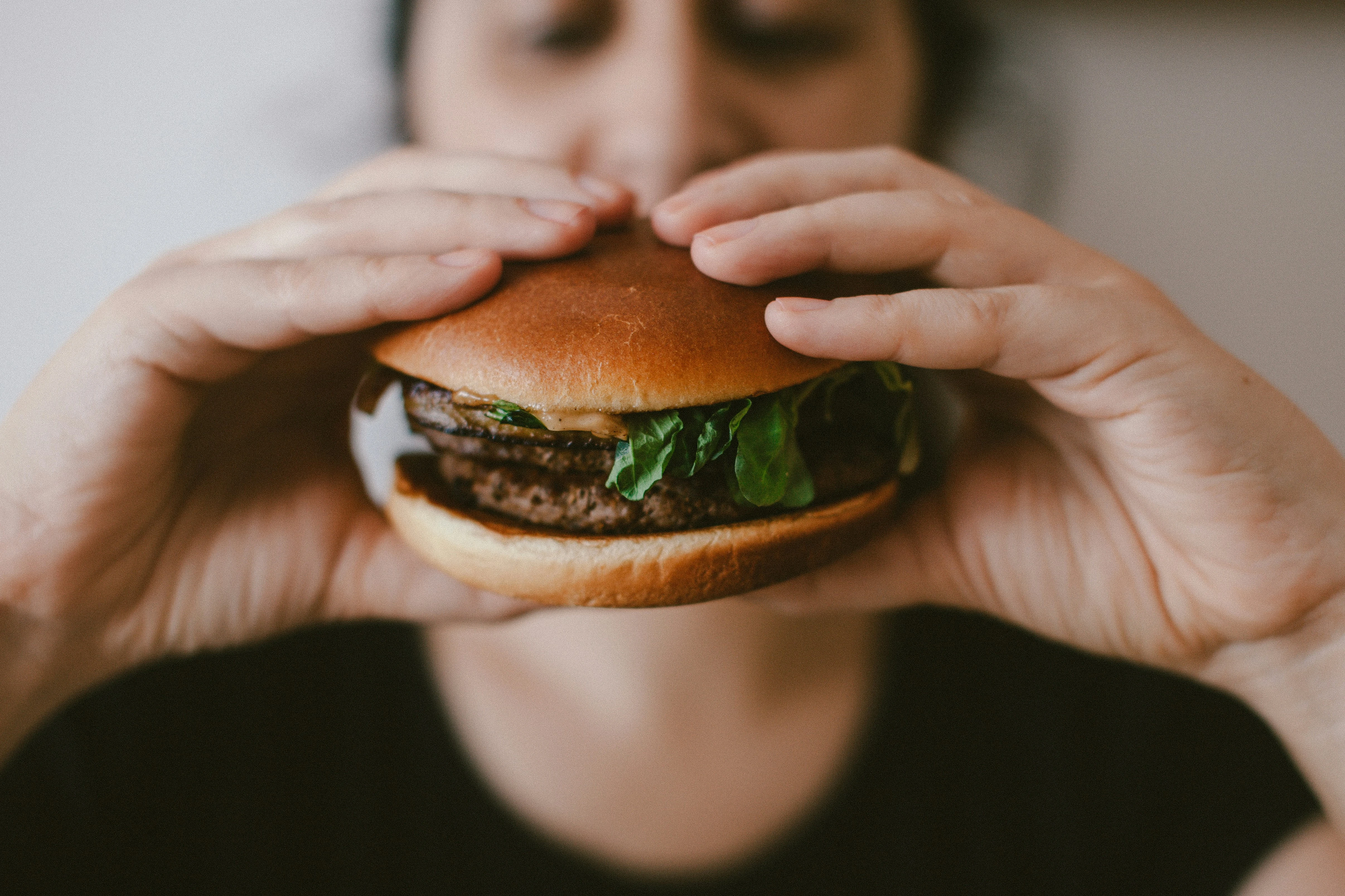 Frau hat einen Burger in der Hand
