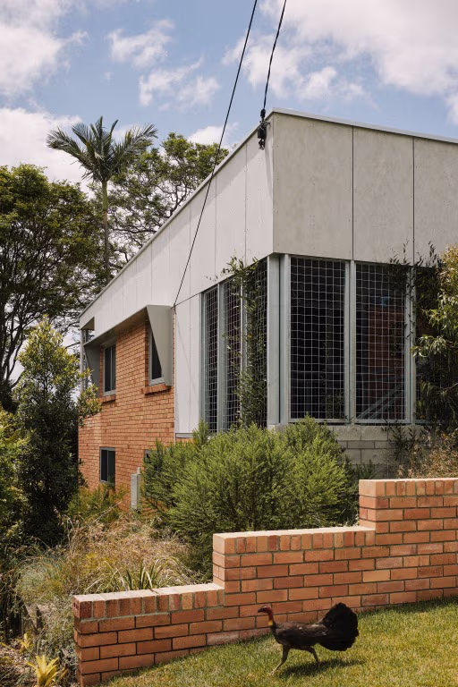 Facade of Sidney built with concrete and brick, blue sky in the background and green grass in the foreground.