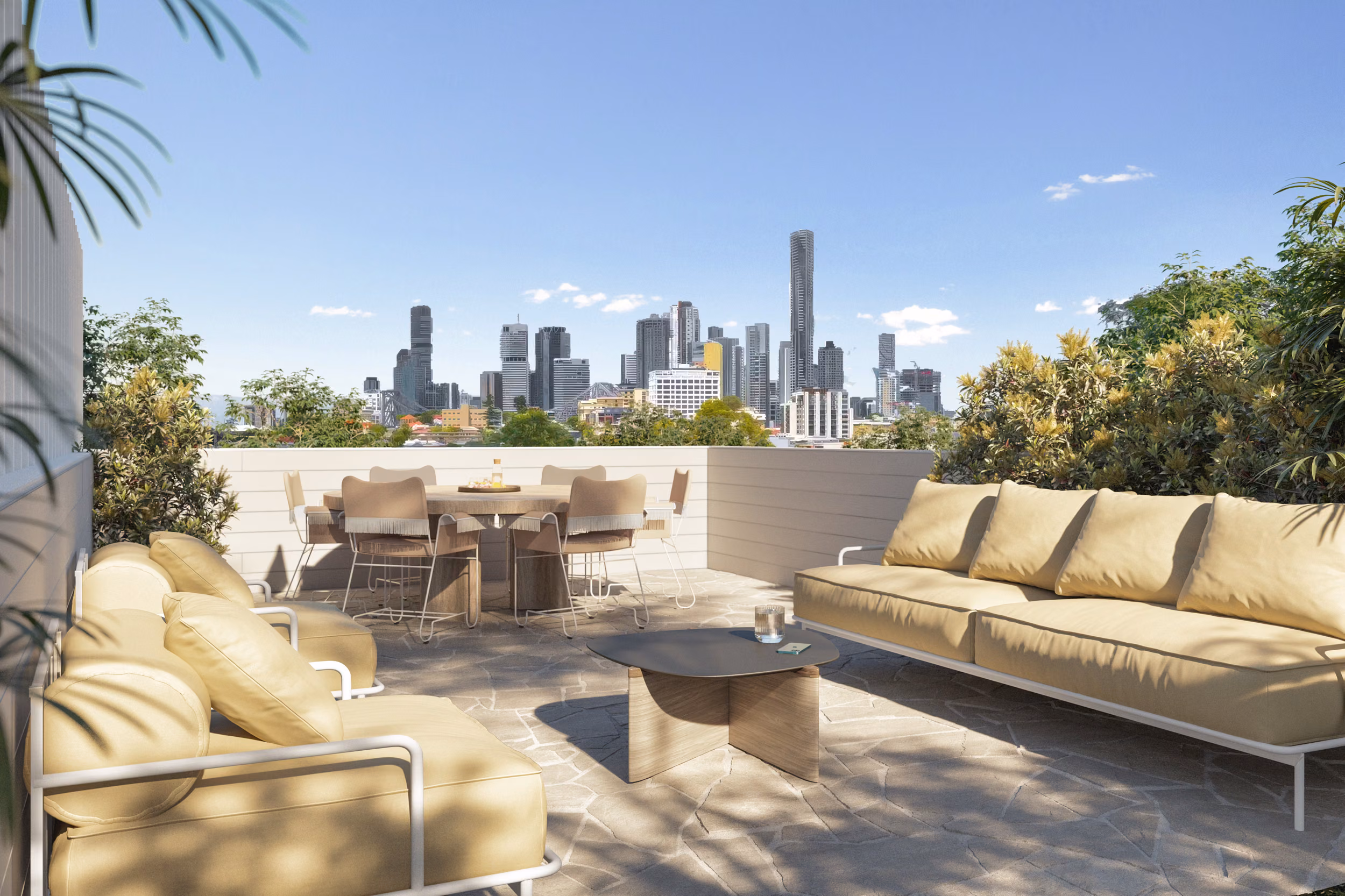 Rooftop terrace furnished with cream outdoor sofas and a round dining setting, framed by lush plantings with panoramic Brisbane city skyline views