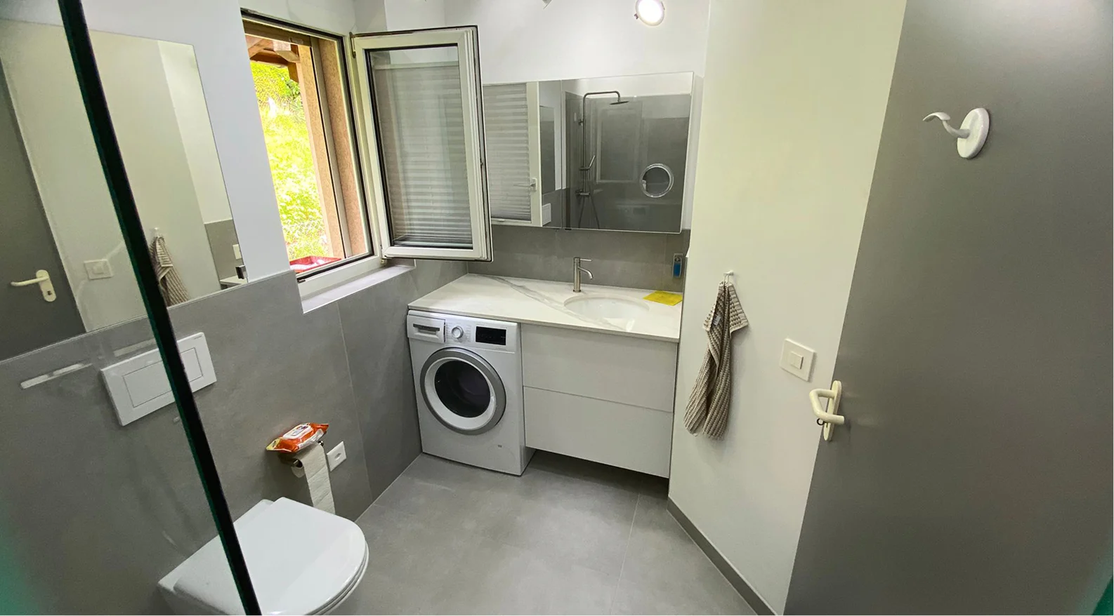 Bagno ristrutturato con gres grigio e mobile sospeso in Ticino