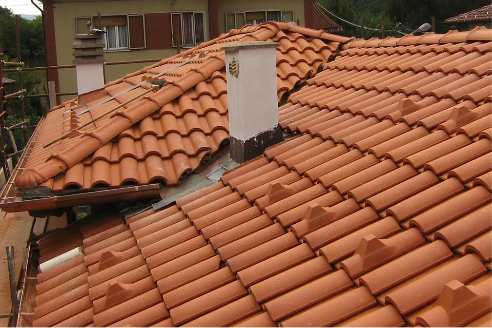 Rifacimento tetto con tegole in laterizio e comignolo intonacato in Ticino