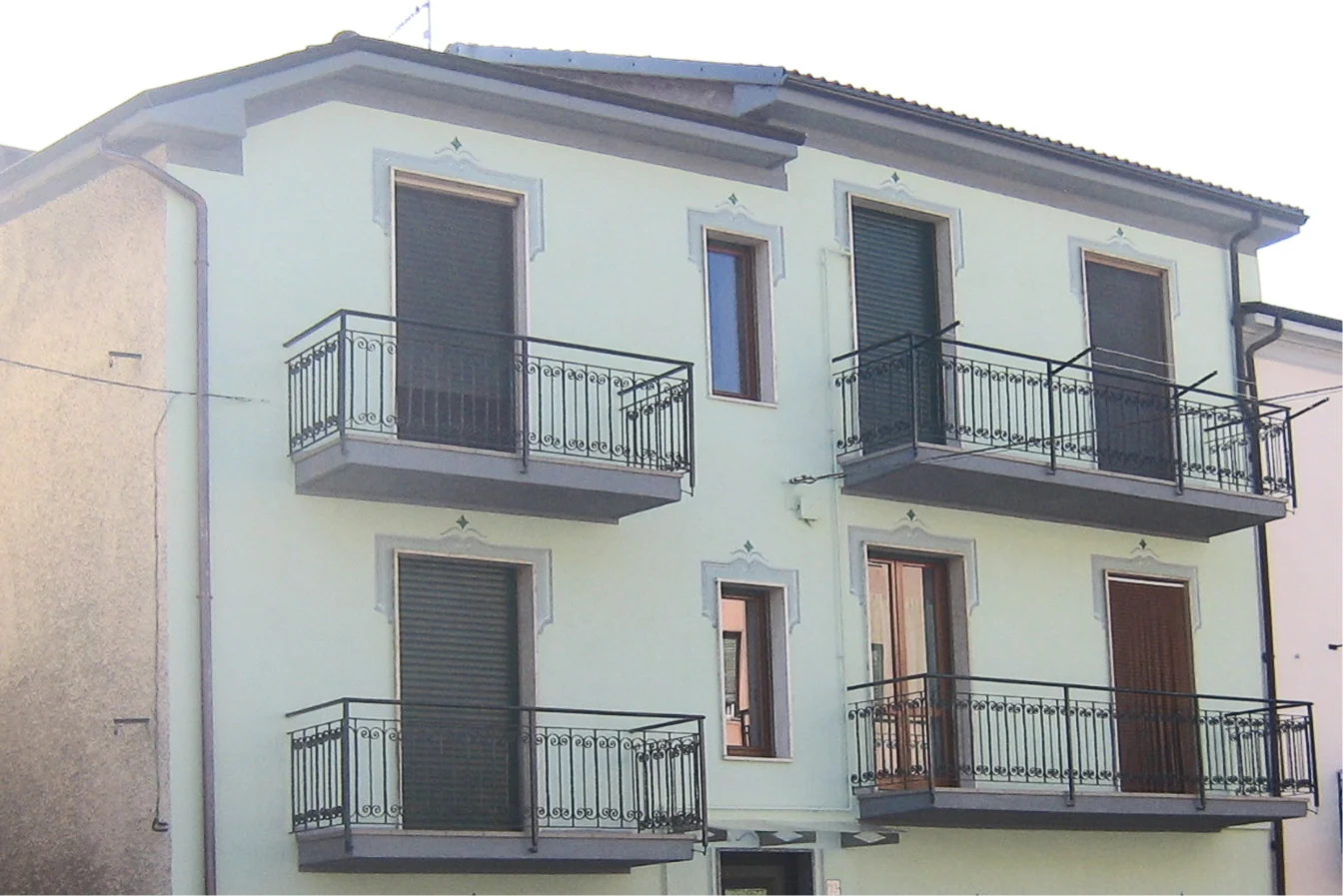 Facciata residenziale rifatta con intonaco e cornici grigie, rifacimento facciate