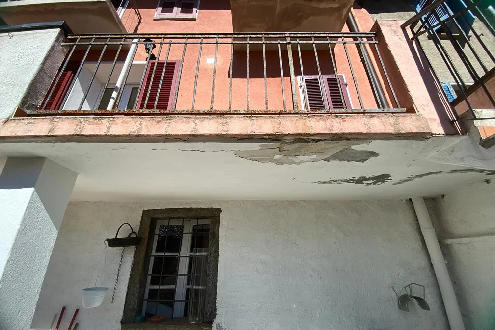 Facciata residenziale con intonaco degradato prima del rifacimento in Ticino