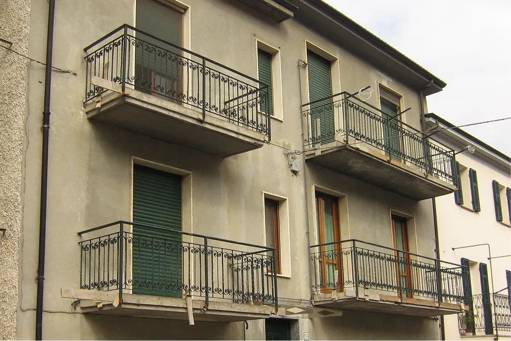 Facciata degradata di edificio residenziale prima del rifacimento in Ticino
