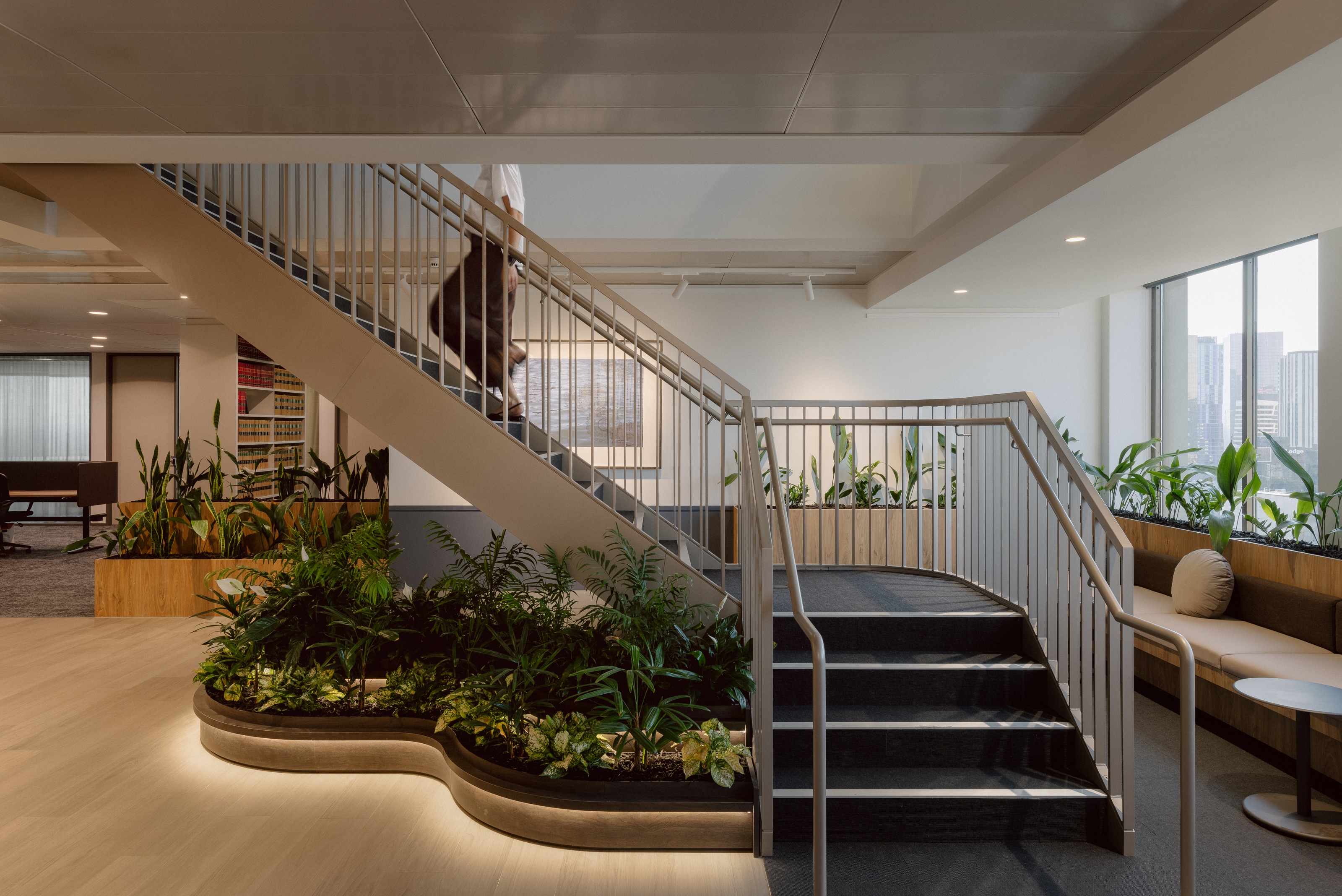 A modern commercial workplace with a staircase and lighting.