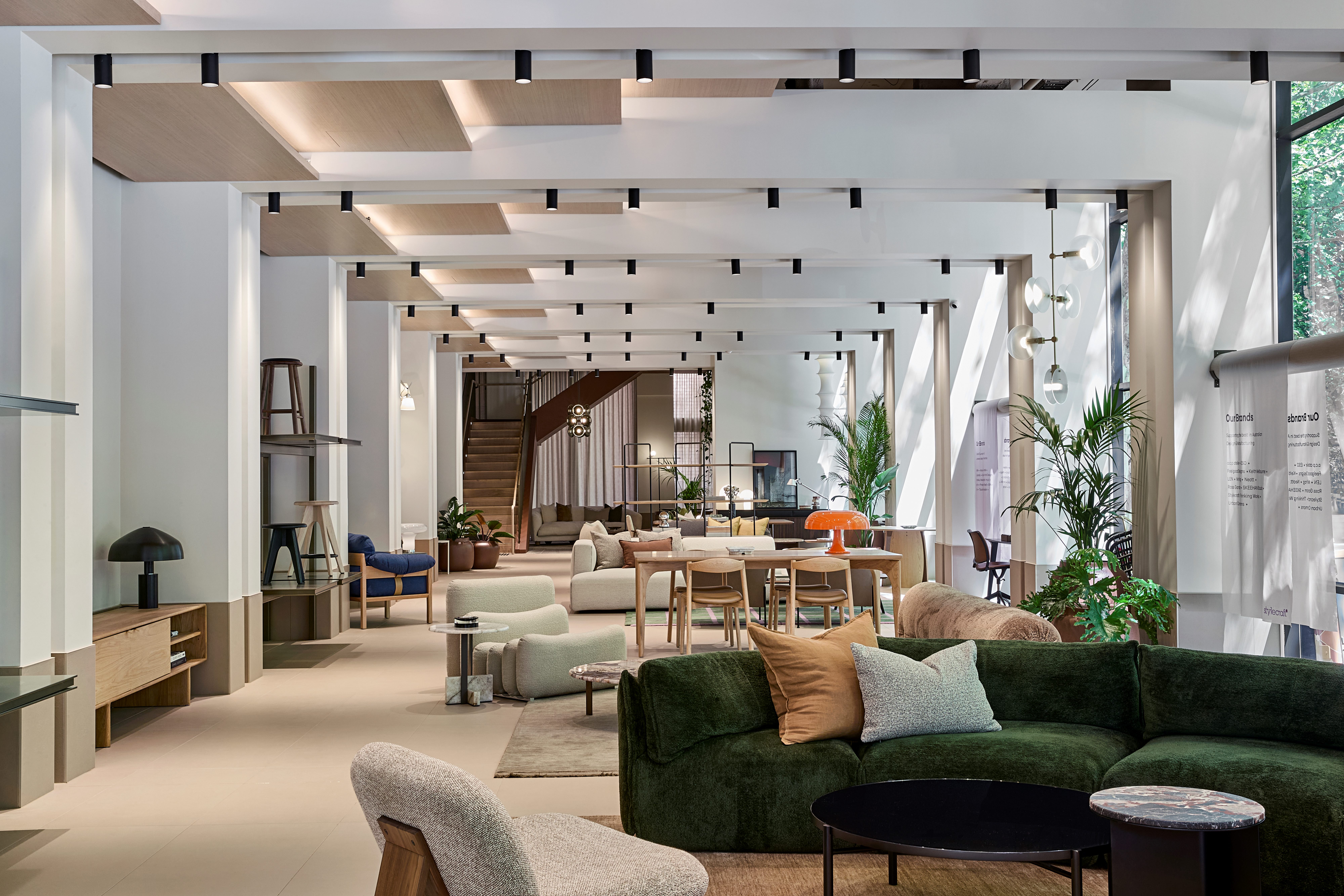 A furniture retail showroom with a green couch in the foreground and architectural archways throughout the space.