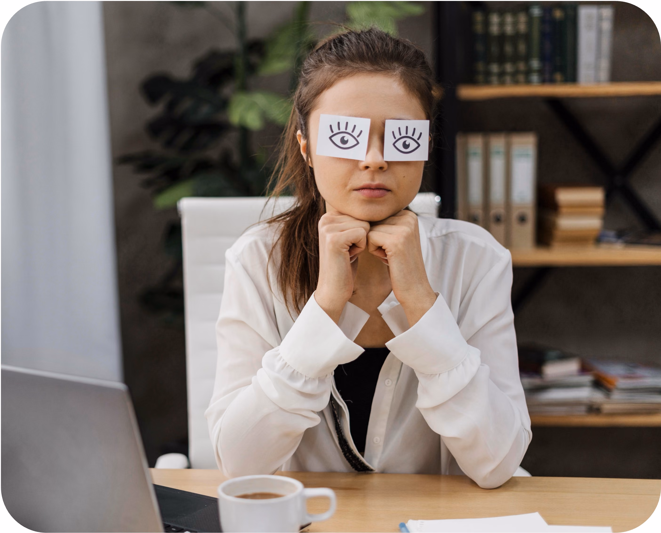 Woman holding paper eyes over her glasses