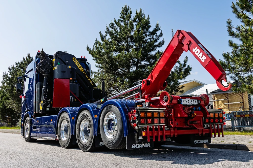 Lastväxlarbil med kran från CMT på en blå Scania