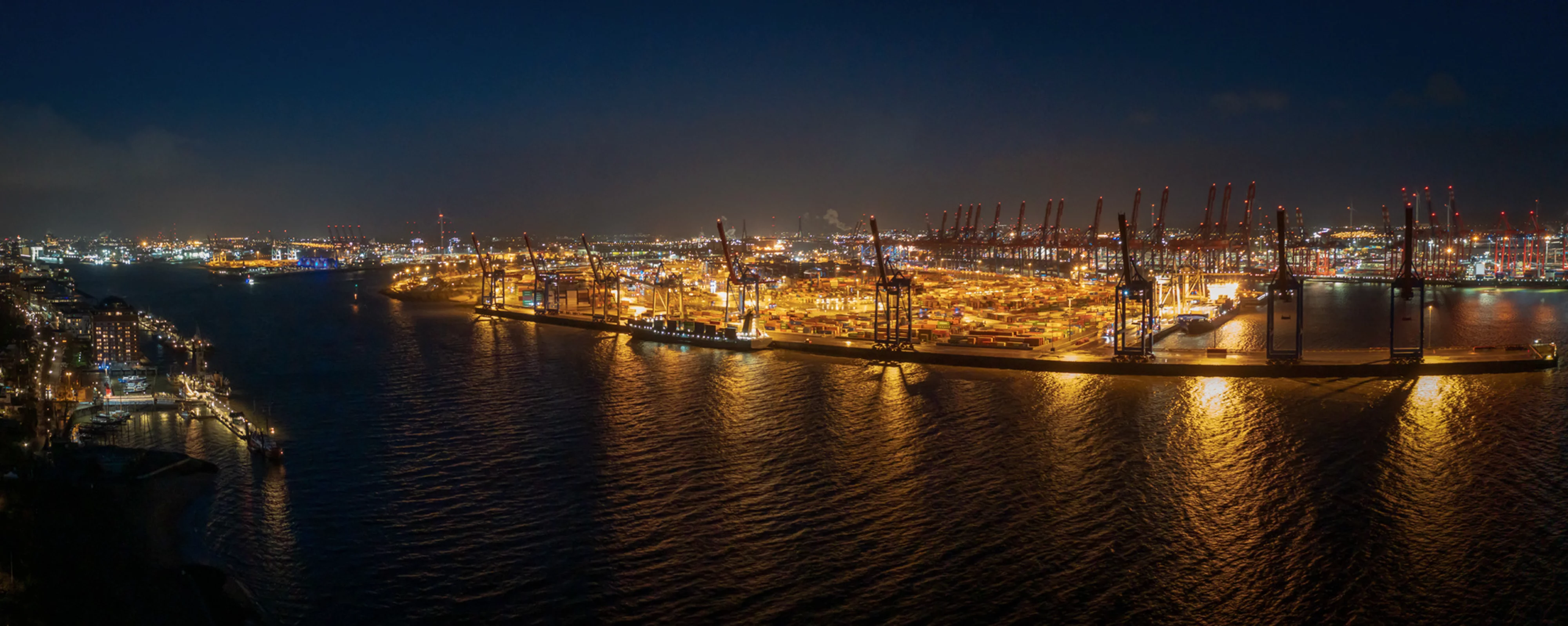 Nächtliches Panorama des Hamburger Hafens mit beleuchteten Containerterminals