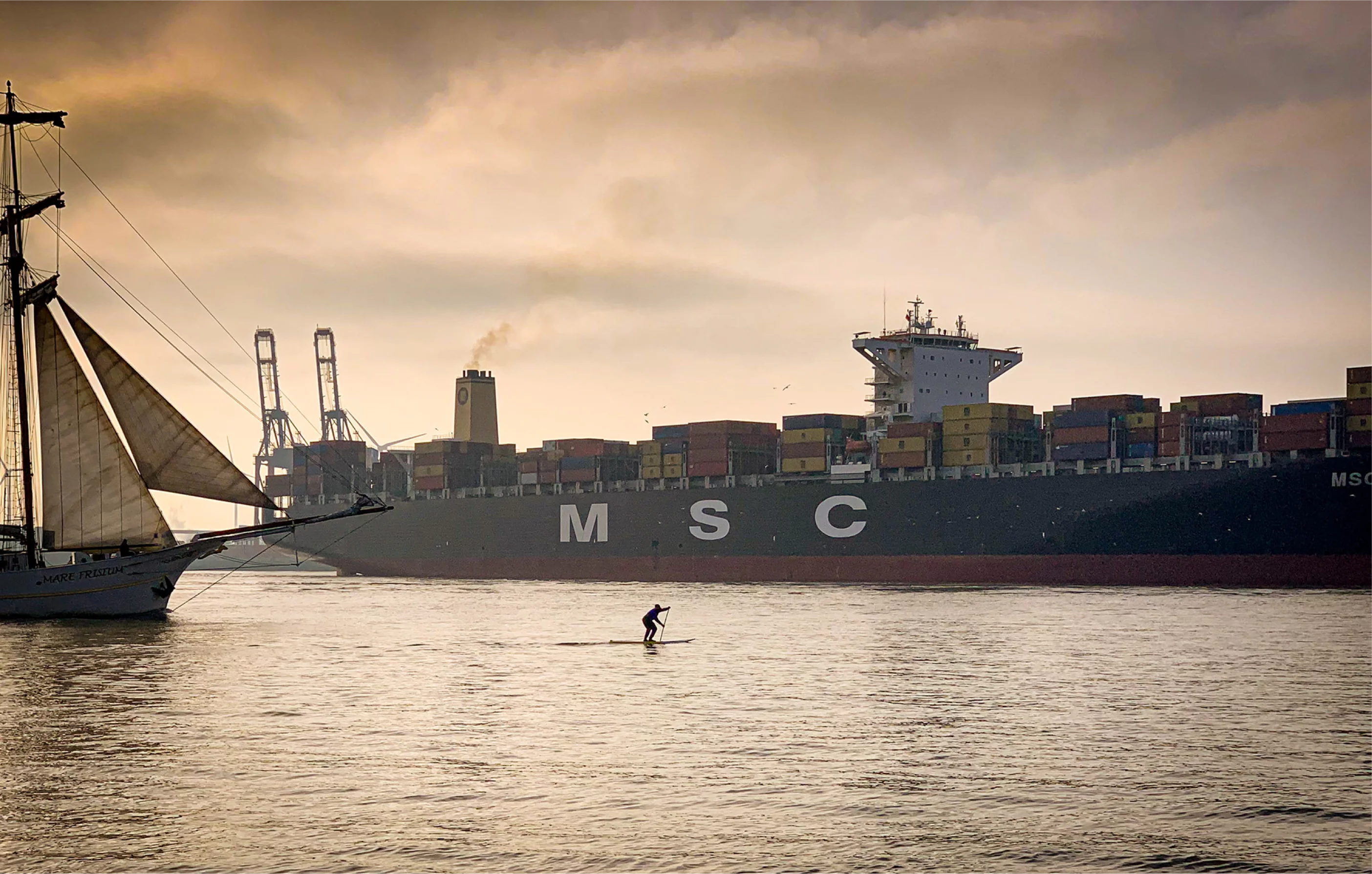 Stand-up-Paddler und historisches Segelschiff im Hamburger Hafen
