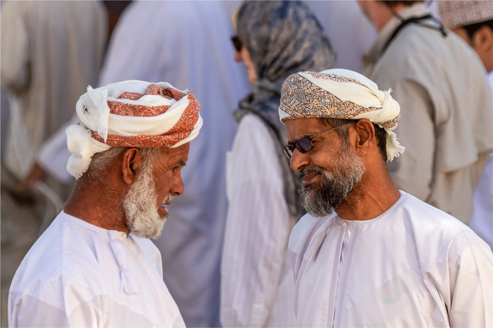 Zwei omanische Männer im traditionellen Dishdasha und Turban im Gespräch