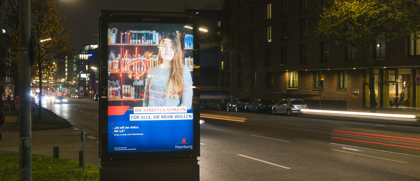 Citylight der Kampagne für die Hamburger Stadtteilschulen an einer Hamburger Straße bei Nacht