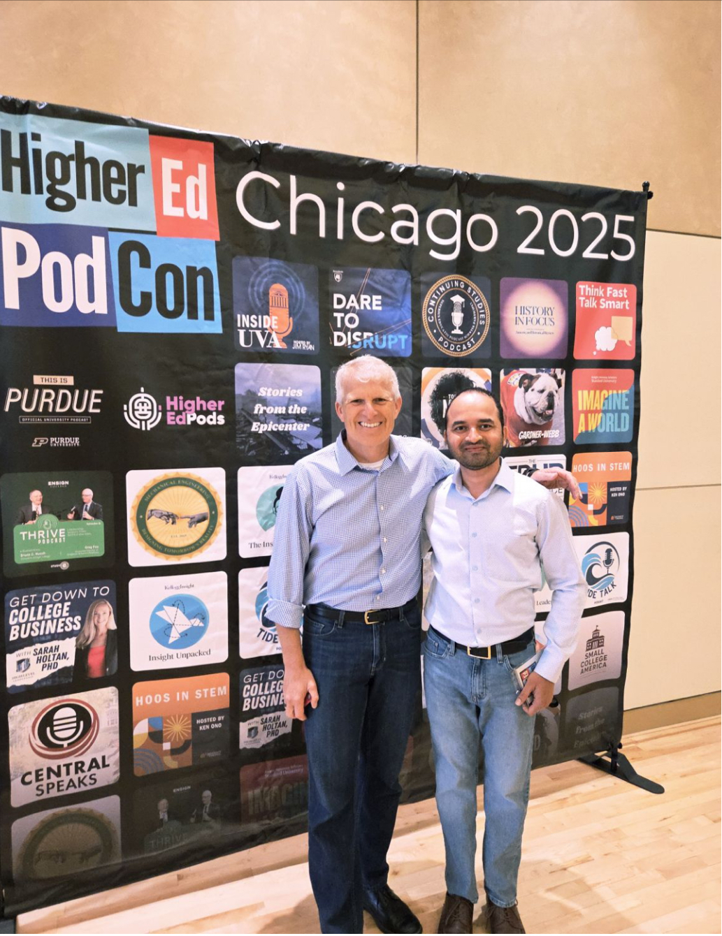Posing in front of the wall of podcasts