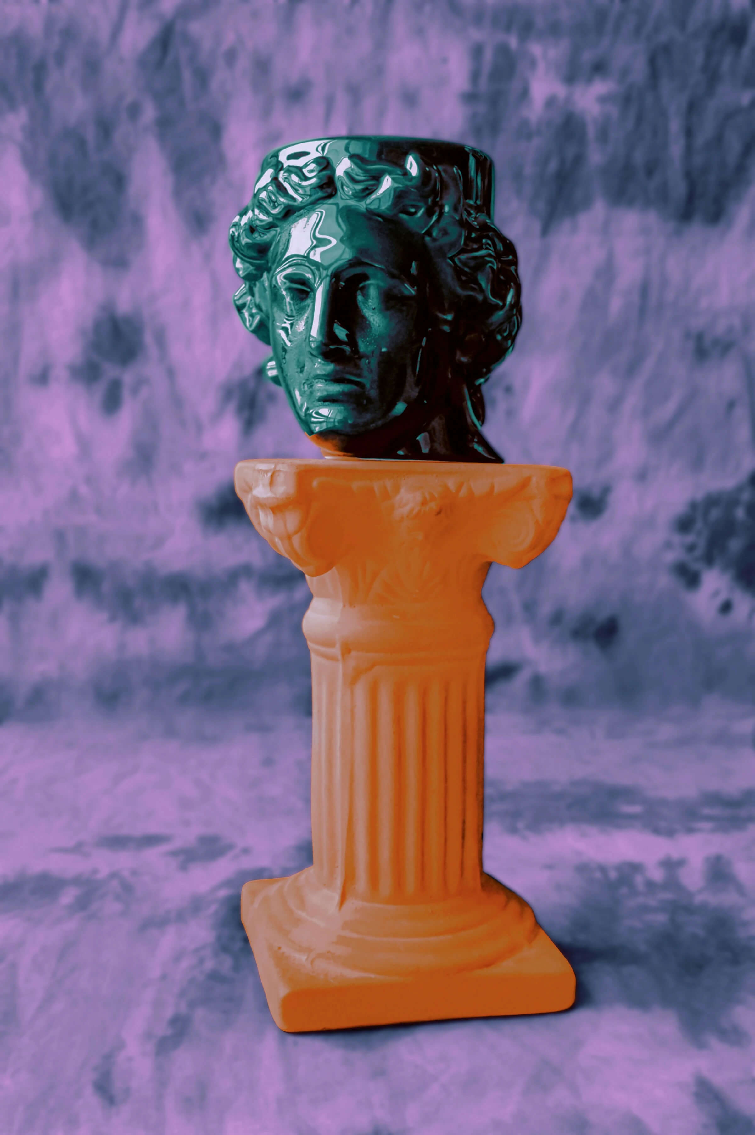 A statue of a man on a pedestal set against a vibrant purple background.
