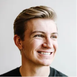 A man with blonde hair smiling at the camera.