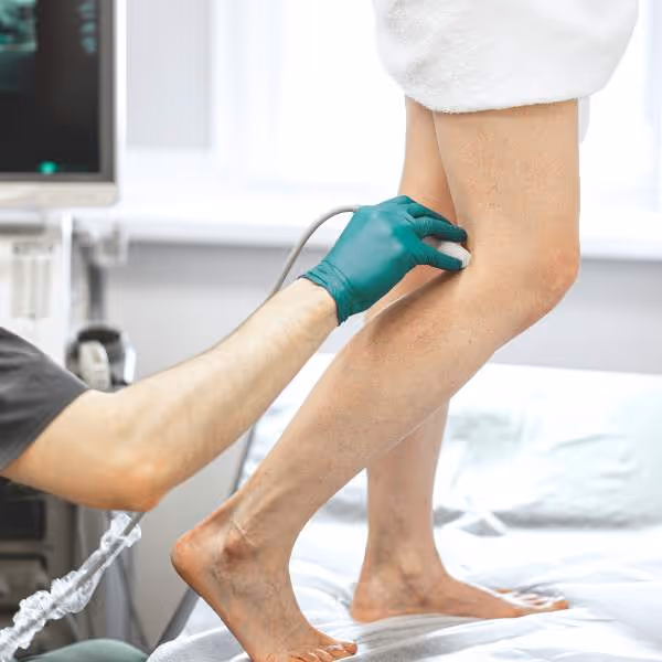 Ein Arzt untersucht mit einem modernen Gerät die Beine einer Patientin