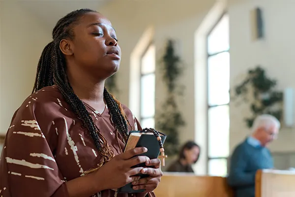 Woman praying in a church.