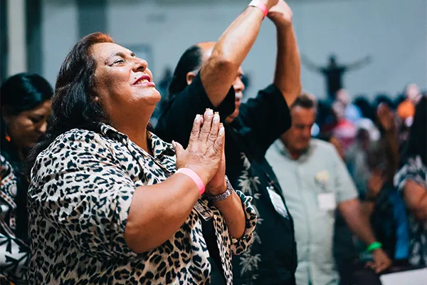 Woman praying at an event.