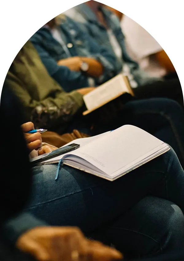 Someone writing in a journal during a talk.